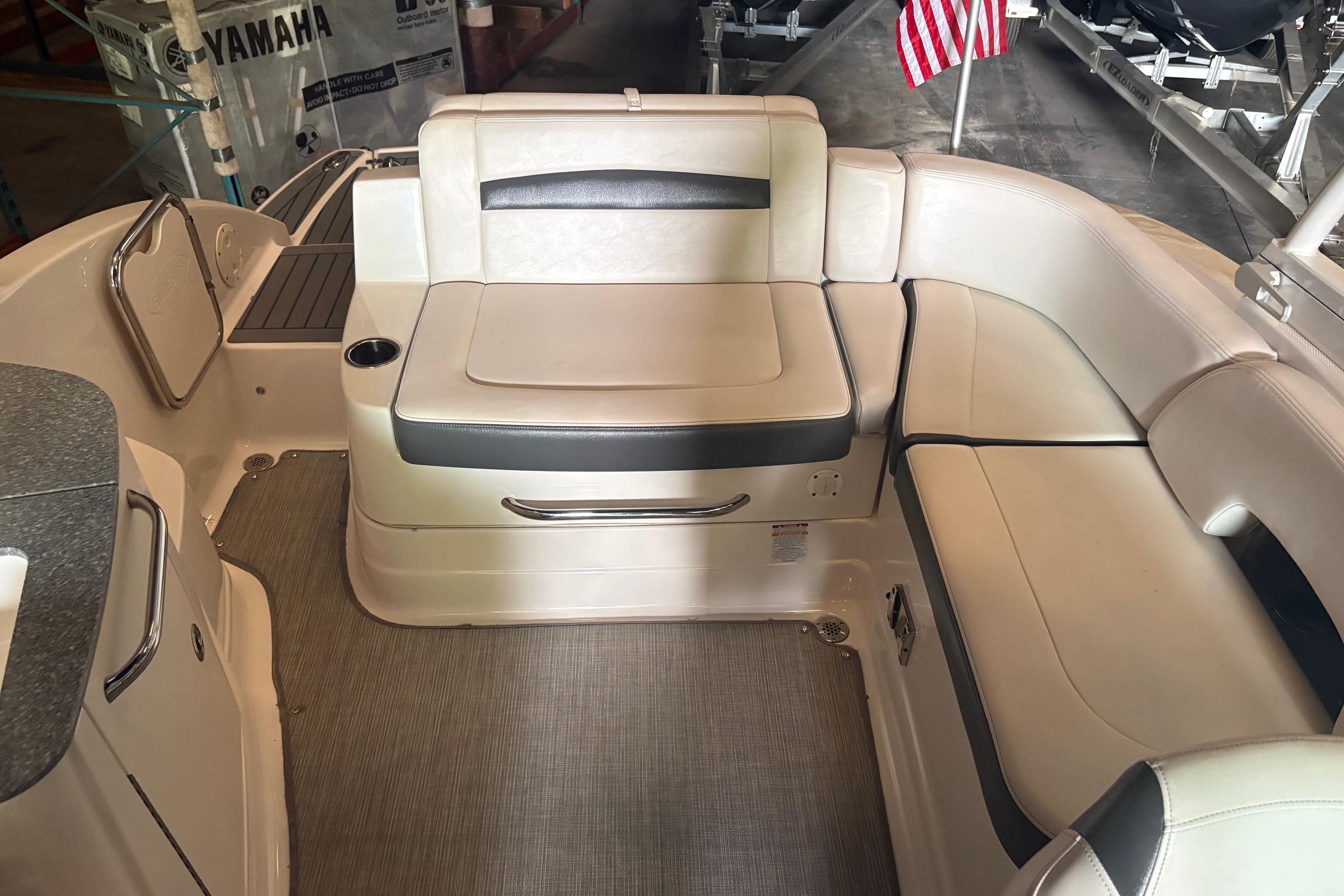 Interior of a 2016 Chaparral 244 Sunesta boat with beige seating and American flag.