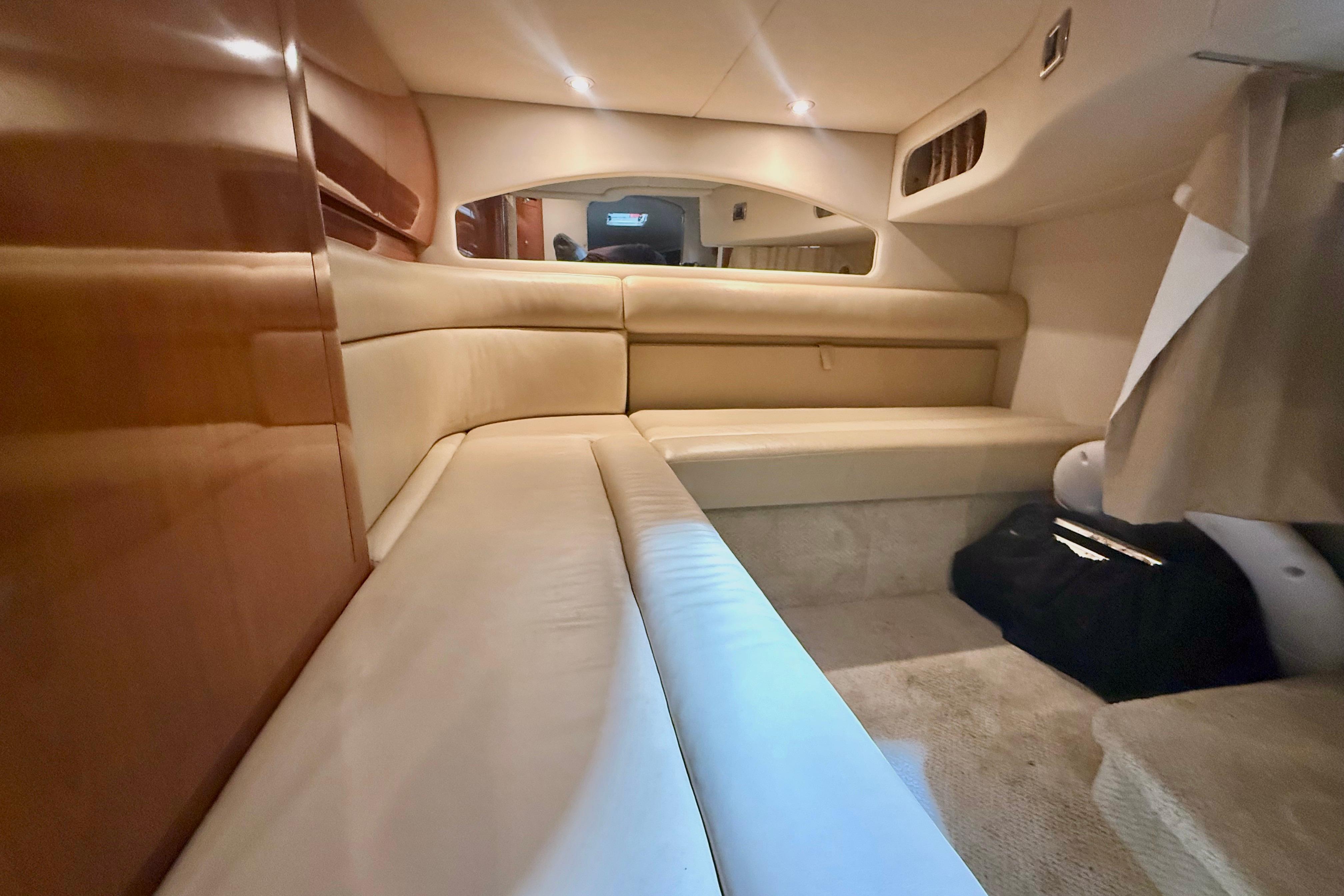 Interior cabin of 2004 Searay 360 Sundancer with beige seating and wood accents.
