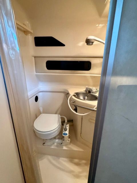 The image shows the bathroom of a 1992 Sea Ray 290 Sundancer with a toilet and sink.