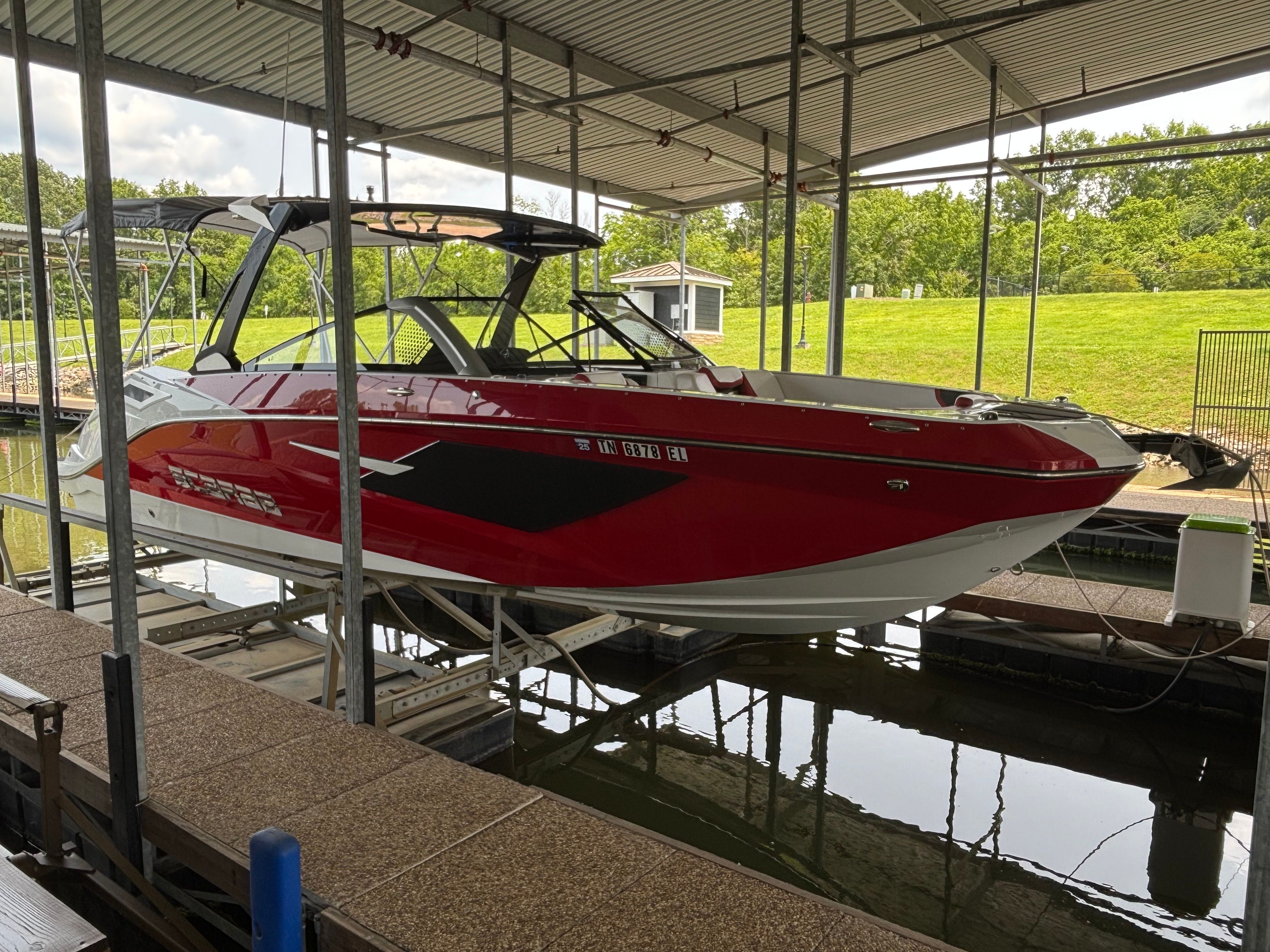 Red 2021 Scarab 285 ID boat docked in marina.