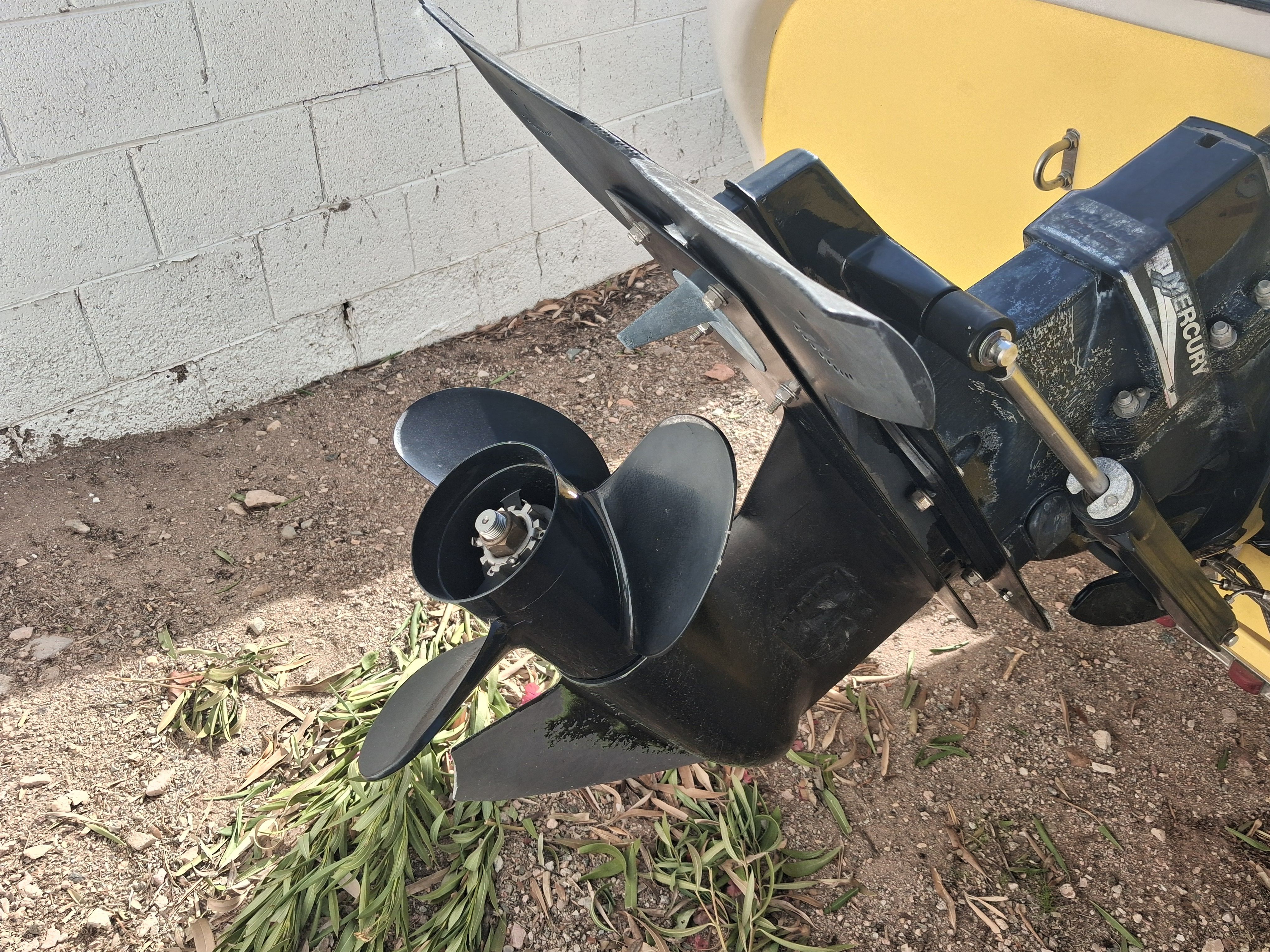 2004 Tracker Tahoe boat motor with propeller on dry ground.
