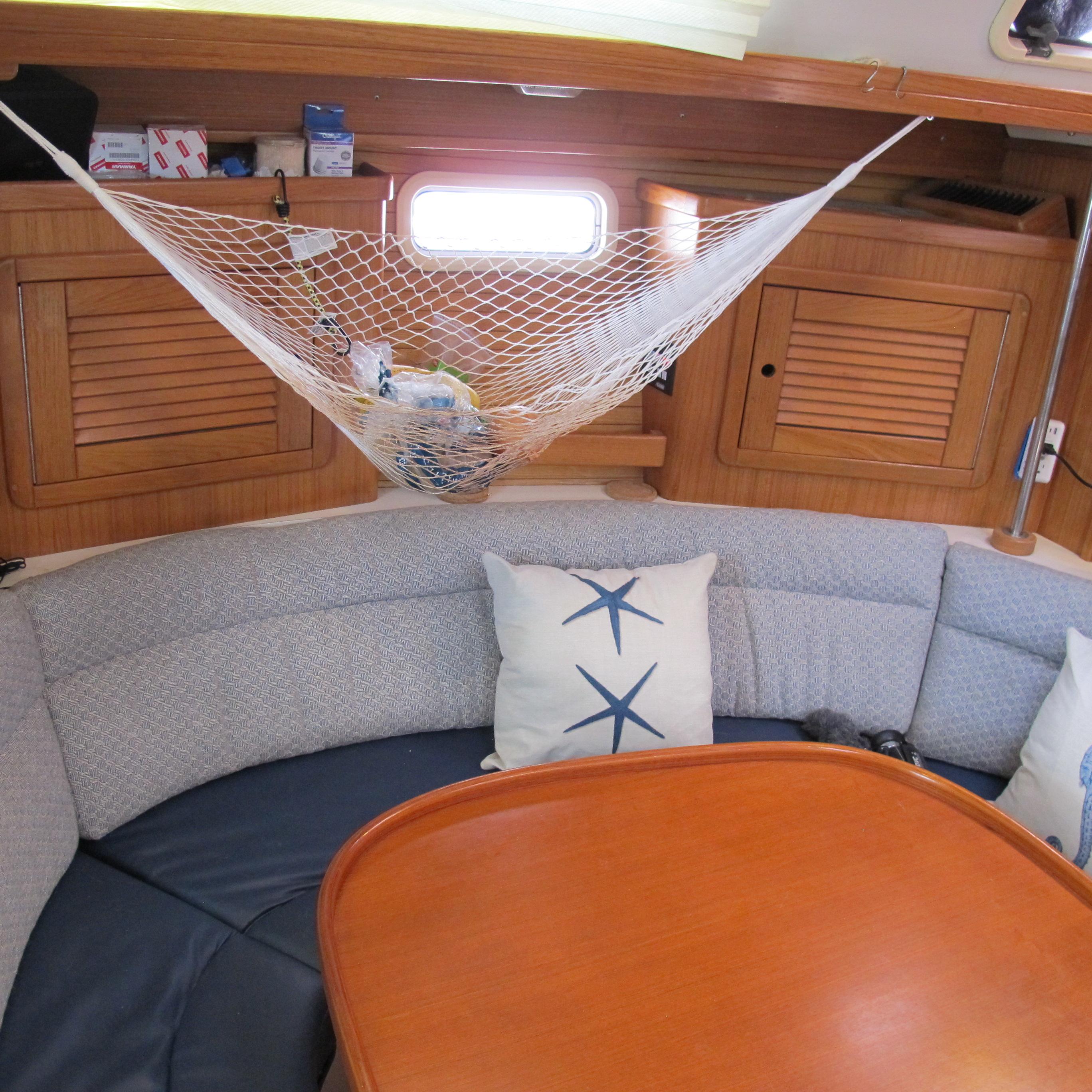 Cozy interior of 1997 Catalina 42 MkII sailboat with net storage and starfish pillows.