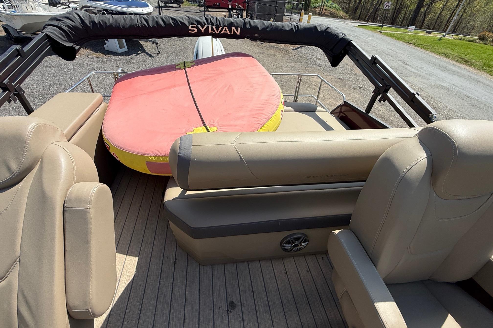 2024 Sylvan X1 CLZ DH boat interior with beige seating and a red inflatable tube.