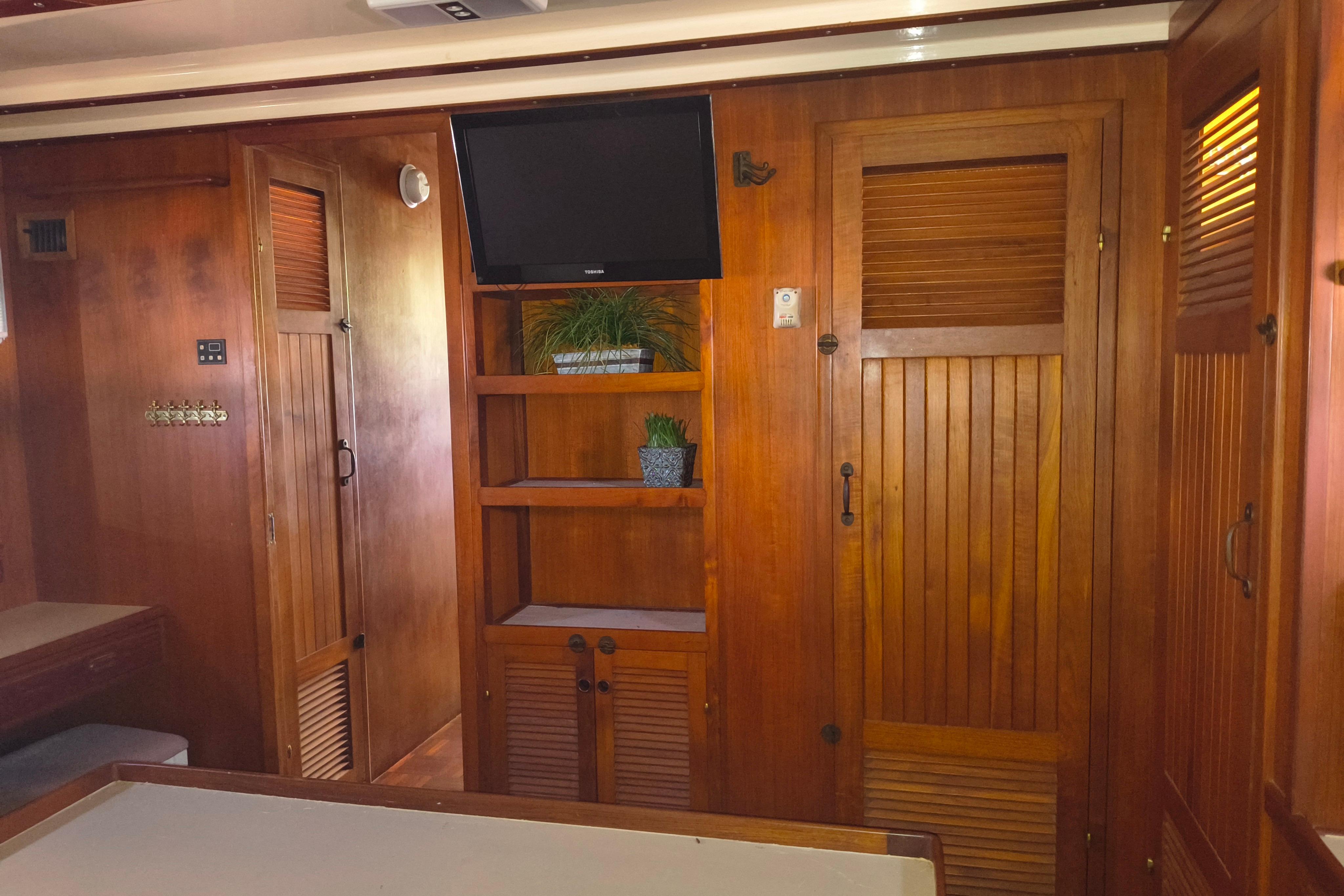 1984 Kadey-Krogen Manatee interior with wooden cabinetry and mounted TV.