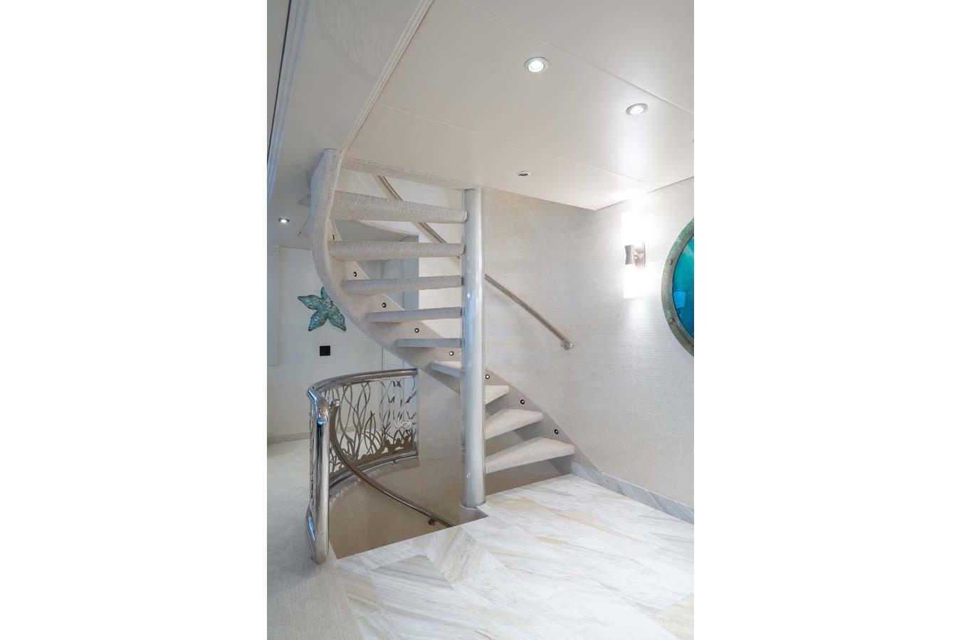 Elegant spiral staircase in 2001 Westship Skylounge yacht interior.