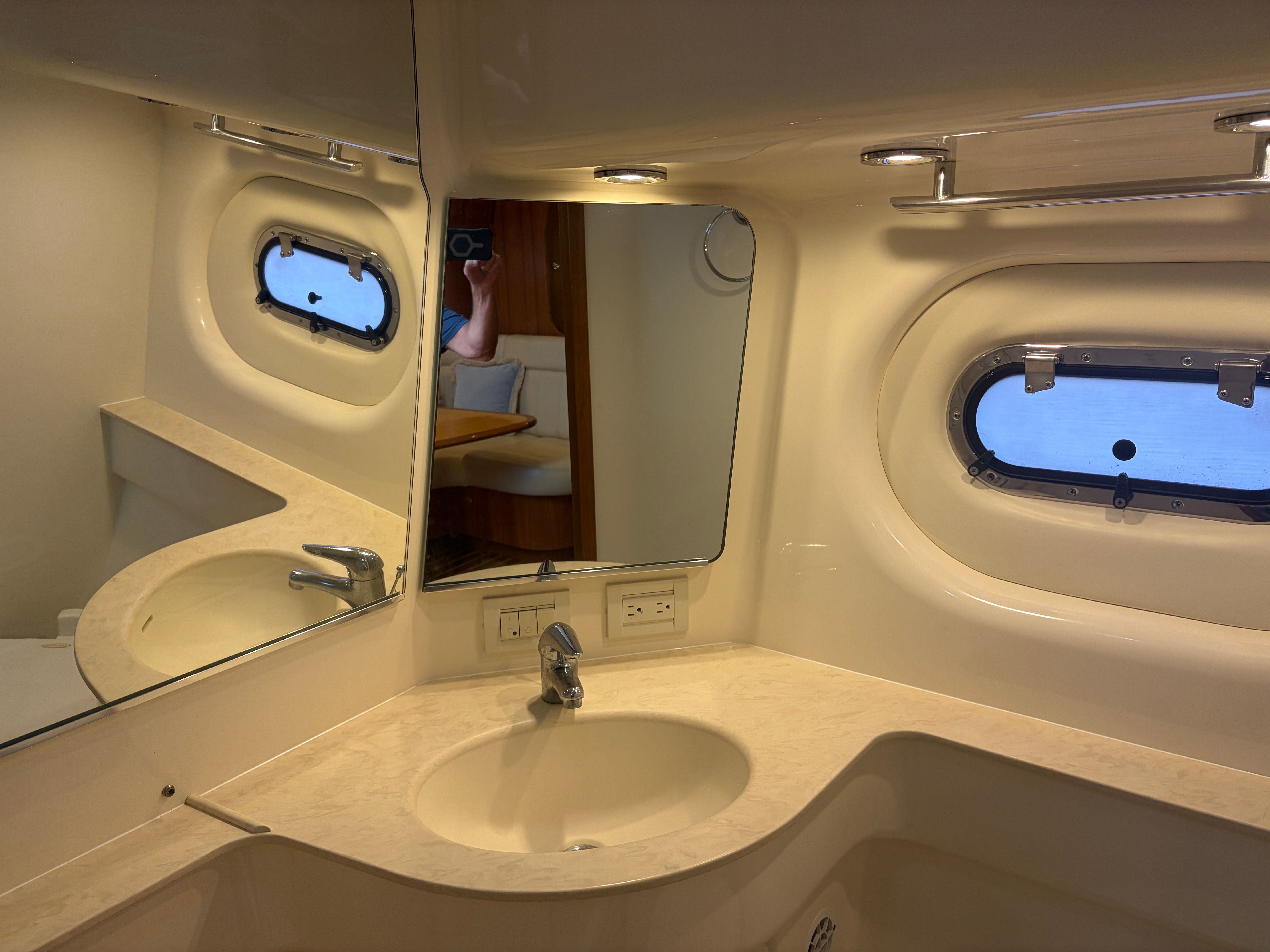 Bathroom in 2005 Tiara Yachts Sovran with mirror and porthole.