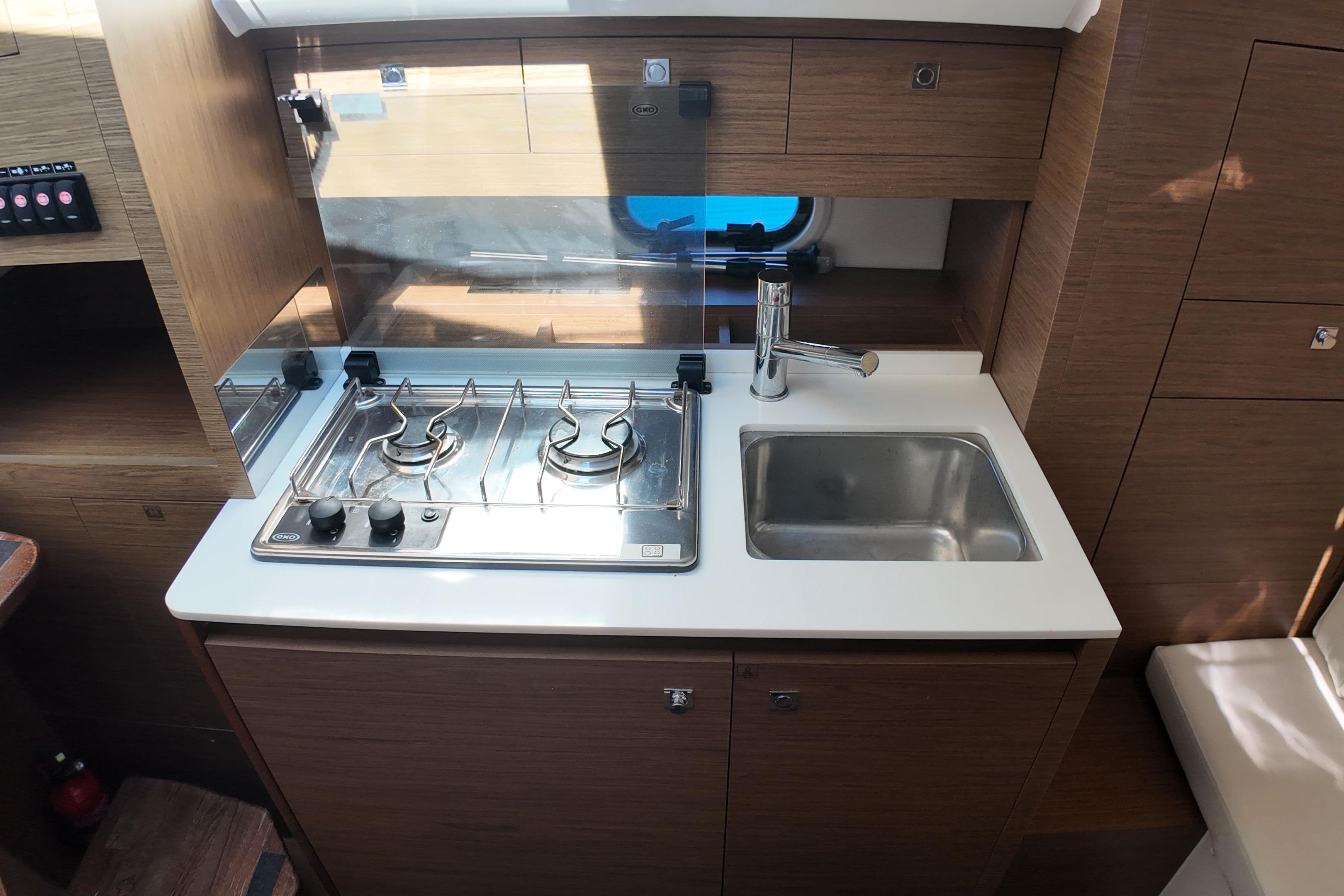 Compact kitchen area in 2018 Cap Camarat 10.5 WA boat with stove and sink.