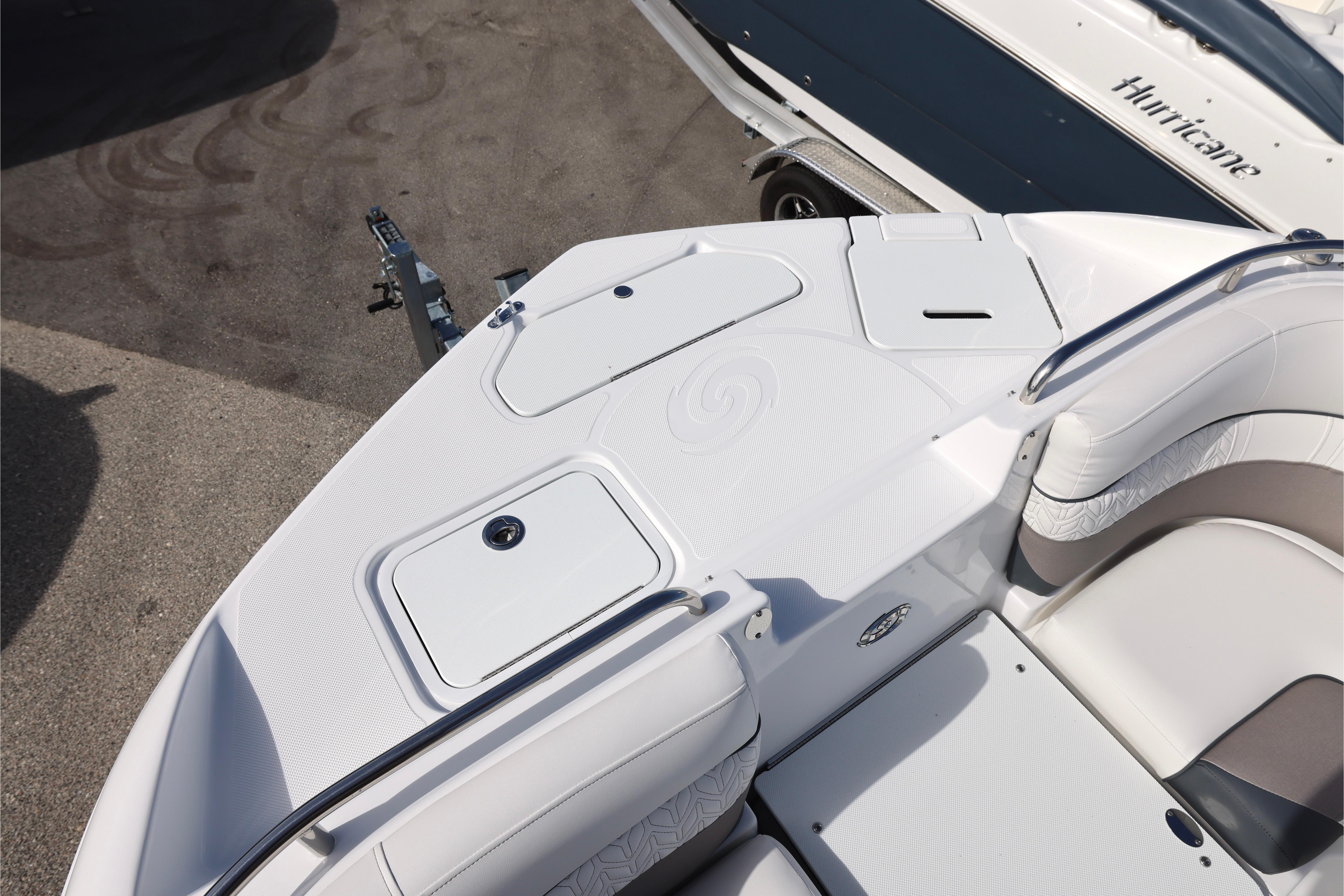 2026 Hurricane SunDeck 2486 OB boat interior, featuring sleek white seating and storage compartments.