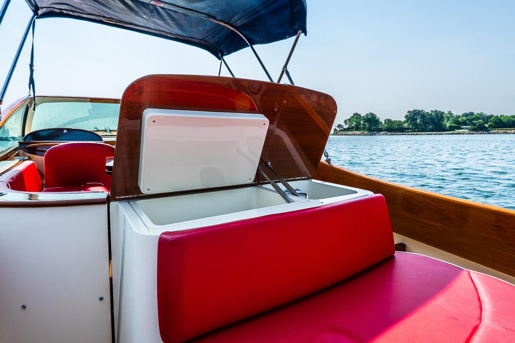 2005 Hinckley Talaria 29R boat interior with red seating and open storage compartment.