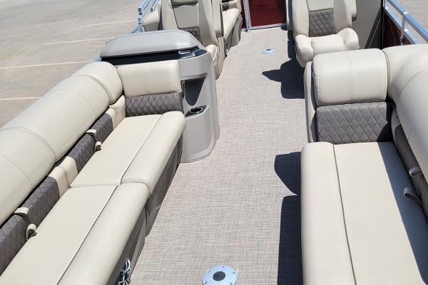 2024 Sun Tracker Party Barge 24 DLX interior with beige seating and spacious layout.