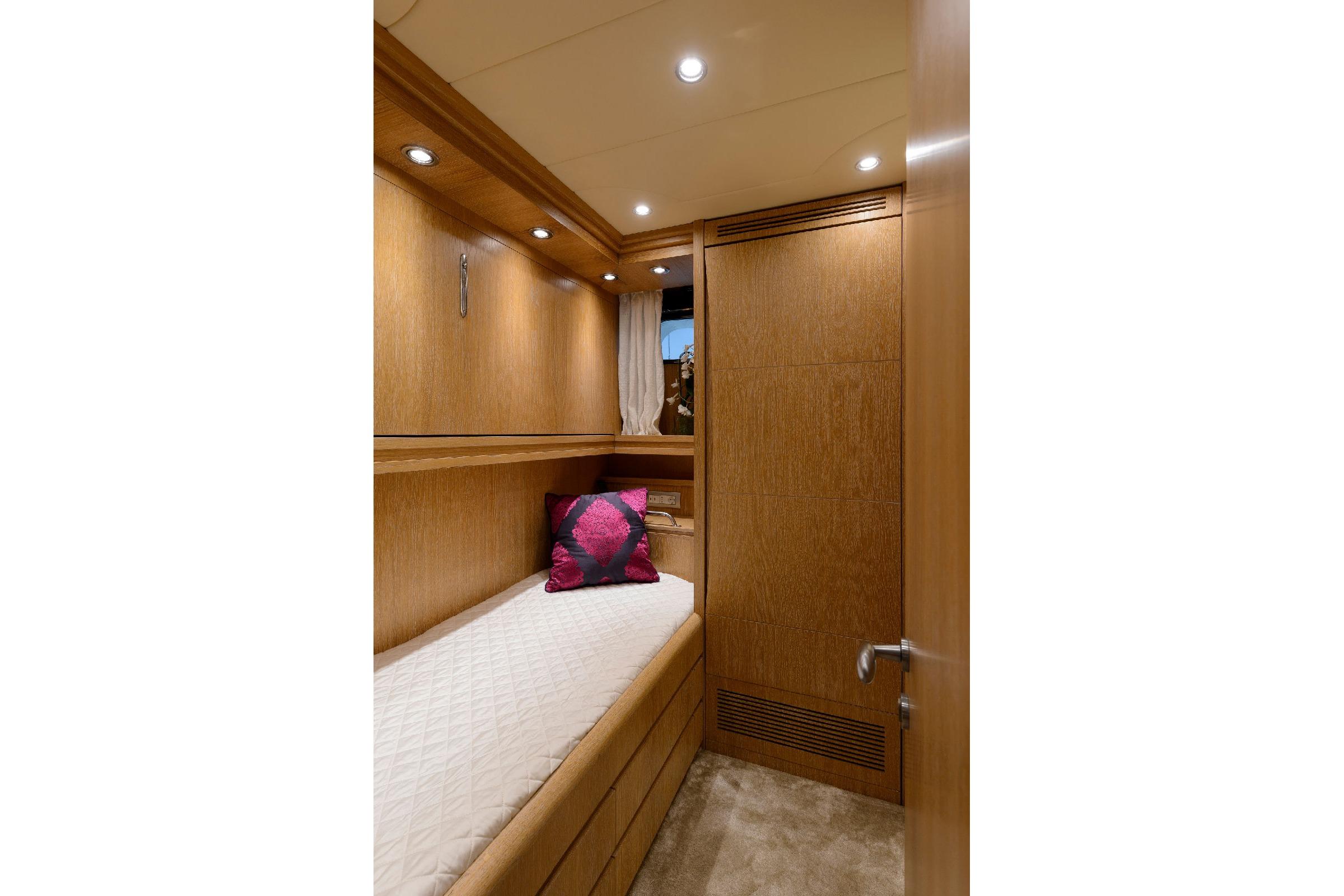 Luxurious wooden cabin interior of 2001 Maiora 31 DP yacht with cozy bedding.