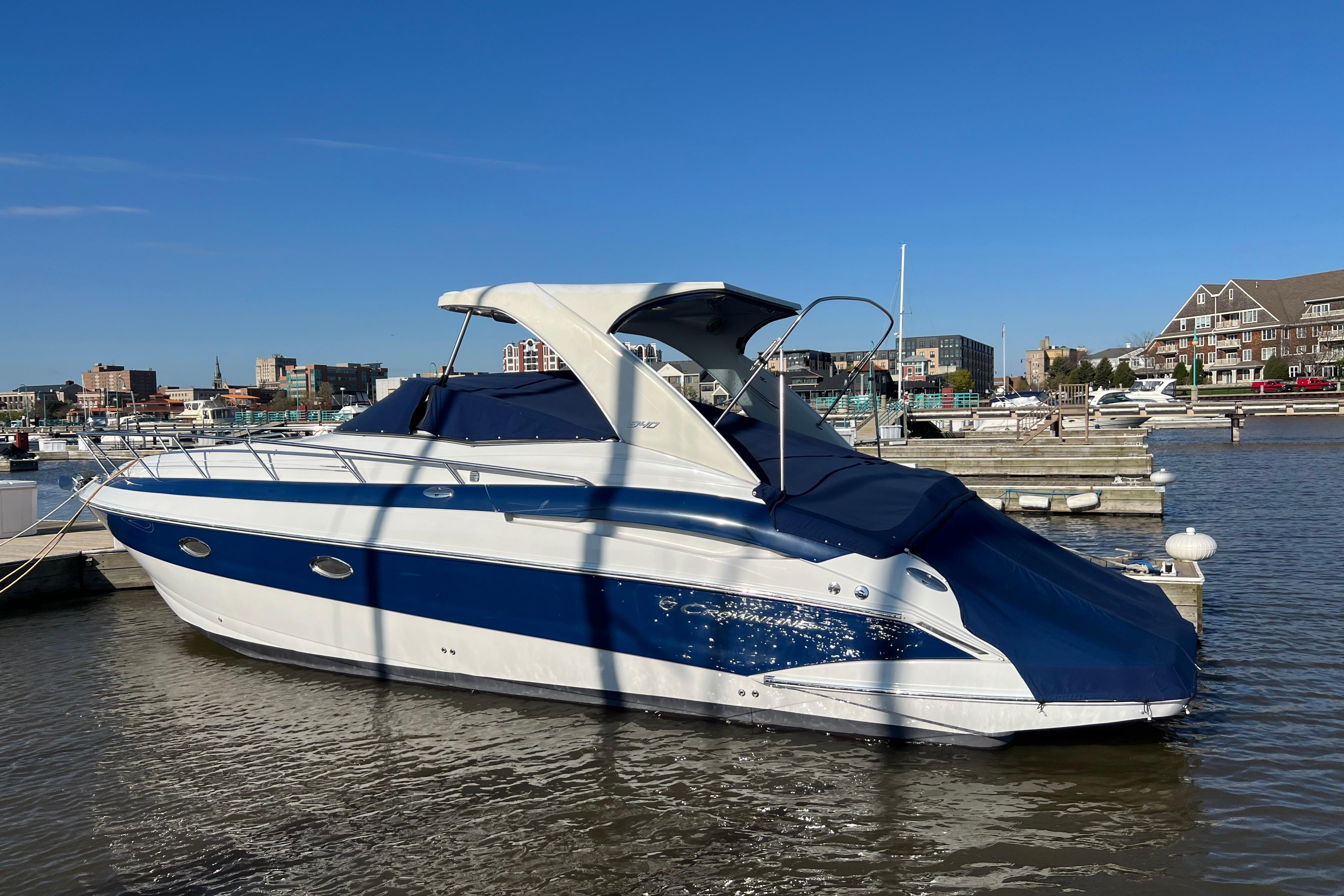 2008 Crownline 340 CR boat docked in a marina under clear blue skies.