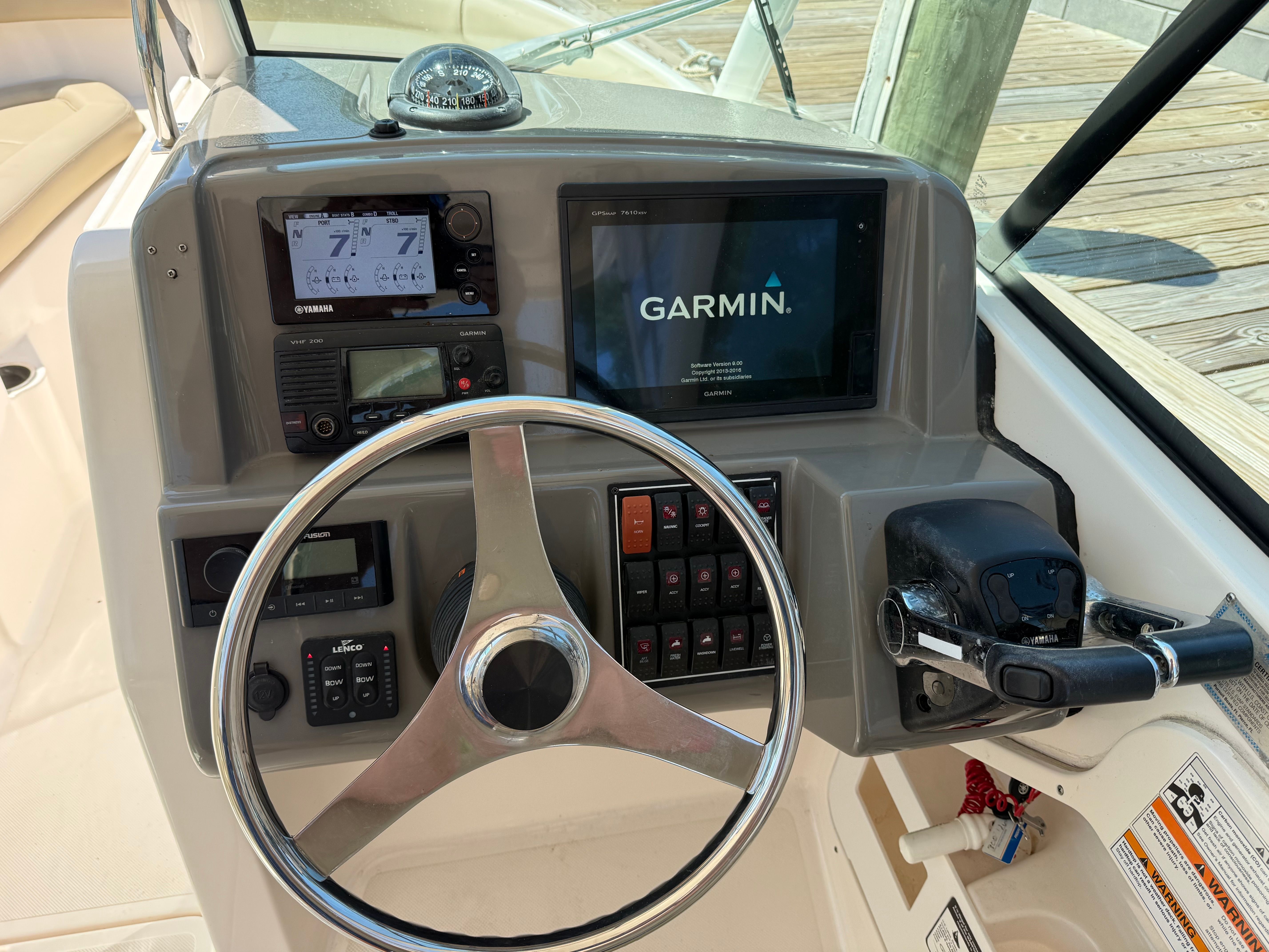 The image shows the helm of a Pursuit DC 265 Dual Console boat with Garmin navigation system.