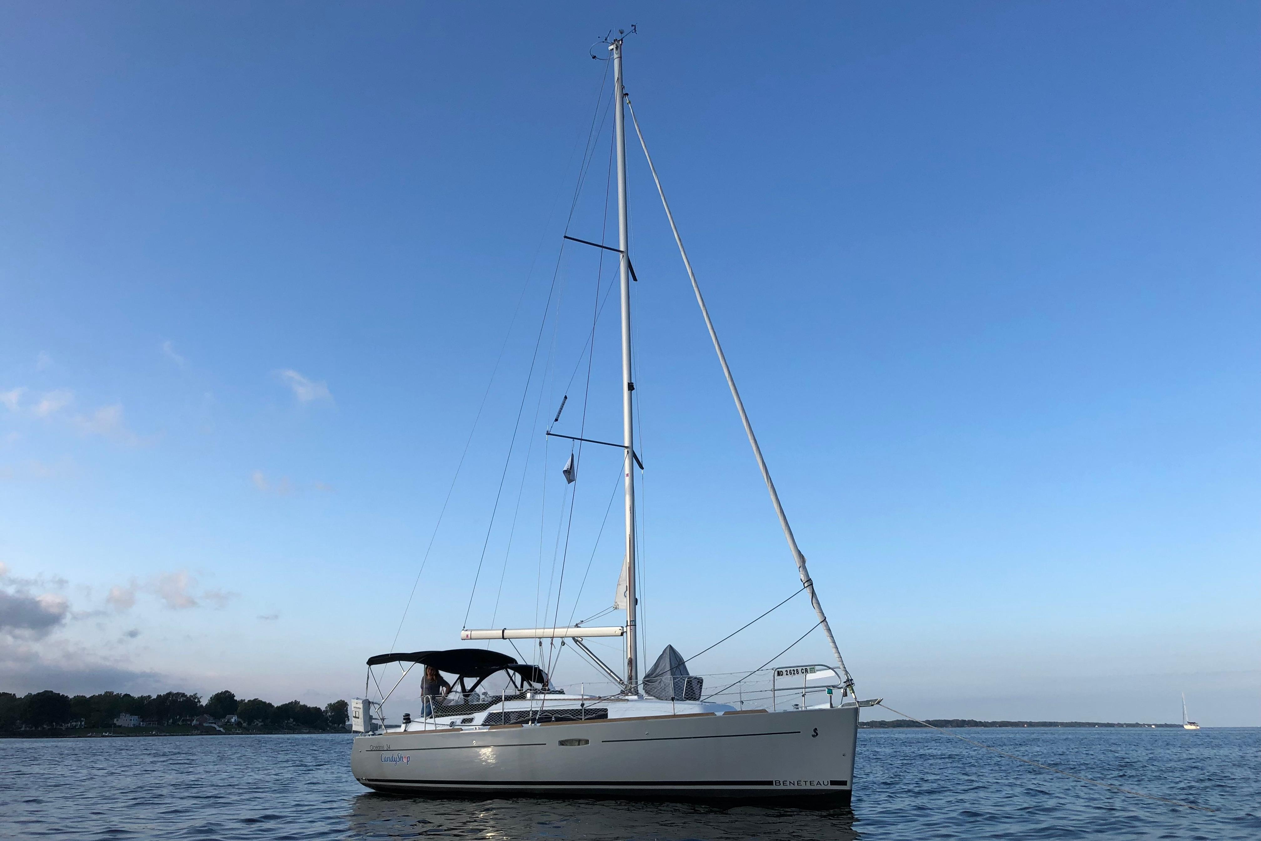 2015 Beneteau Oceanis 34 sailboat on calm water under clear blue sky.