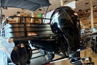 2026 Ranger 220FC boat with powerful outboard motor displayed indoors.
