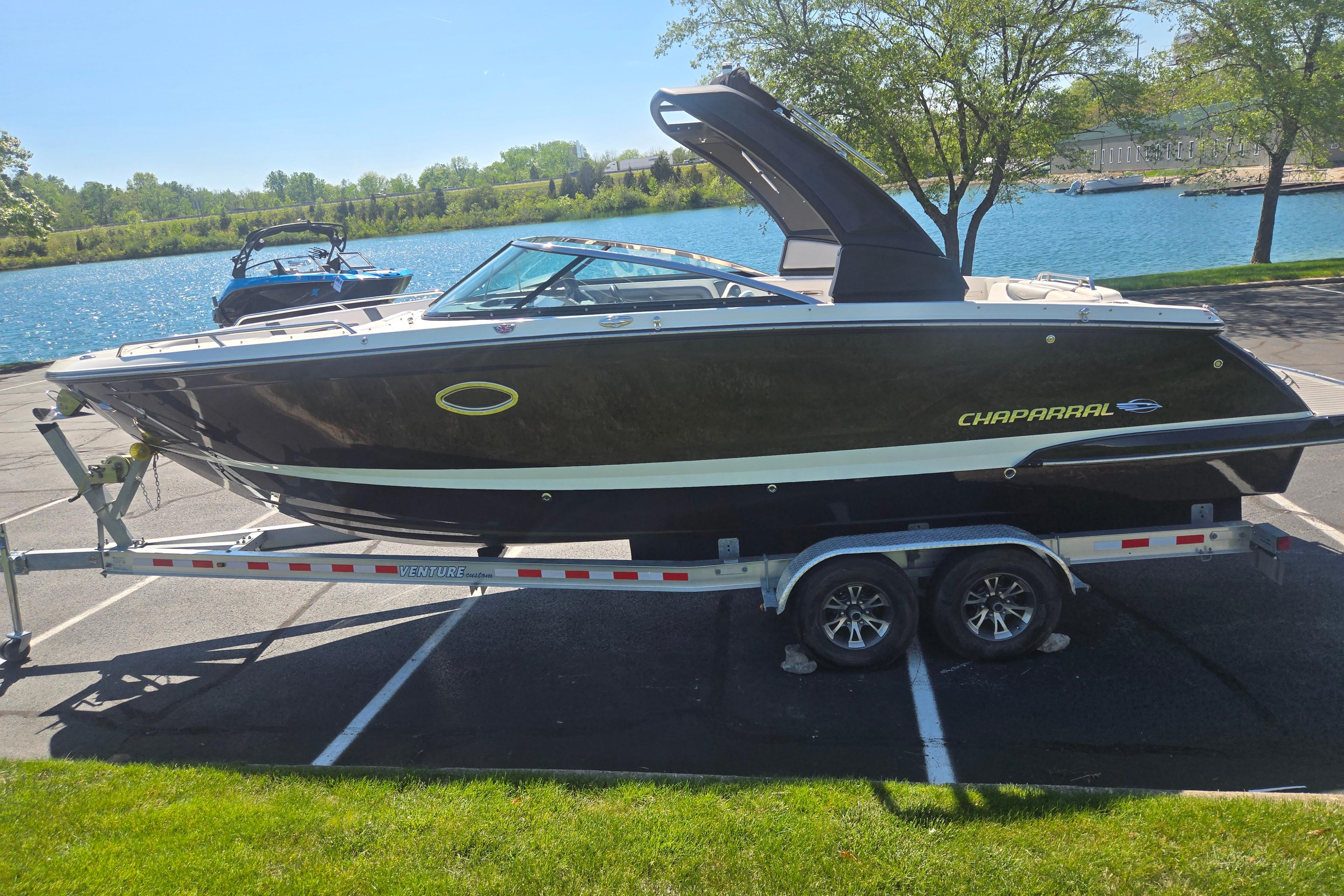 2018 Chaparral 267 SSX boat on trailer by a scenic lake.