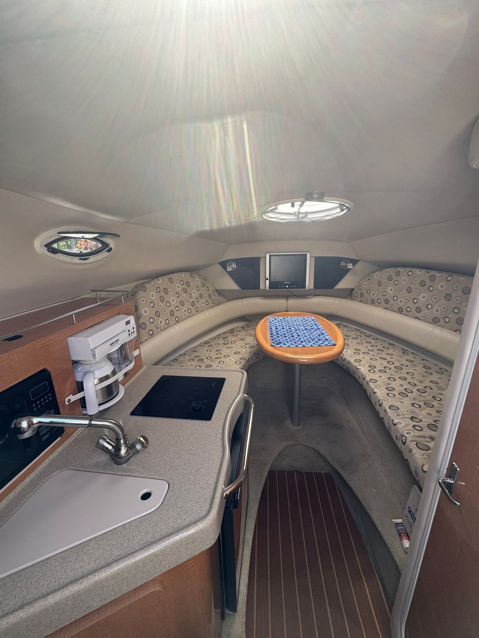 Interior of a modern yacht with a kitchenette and seating area.