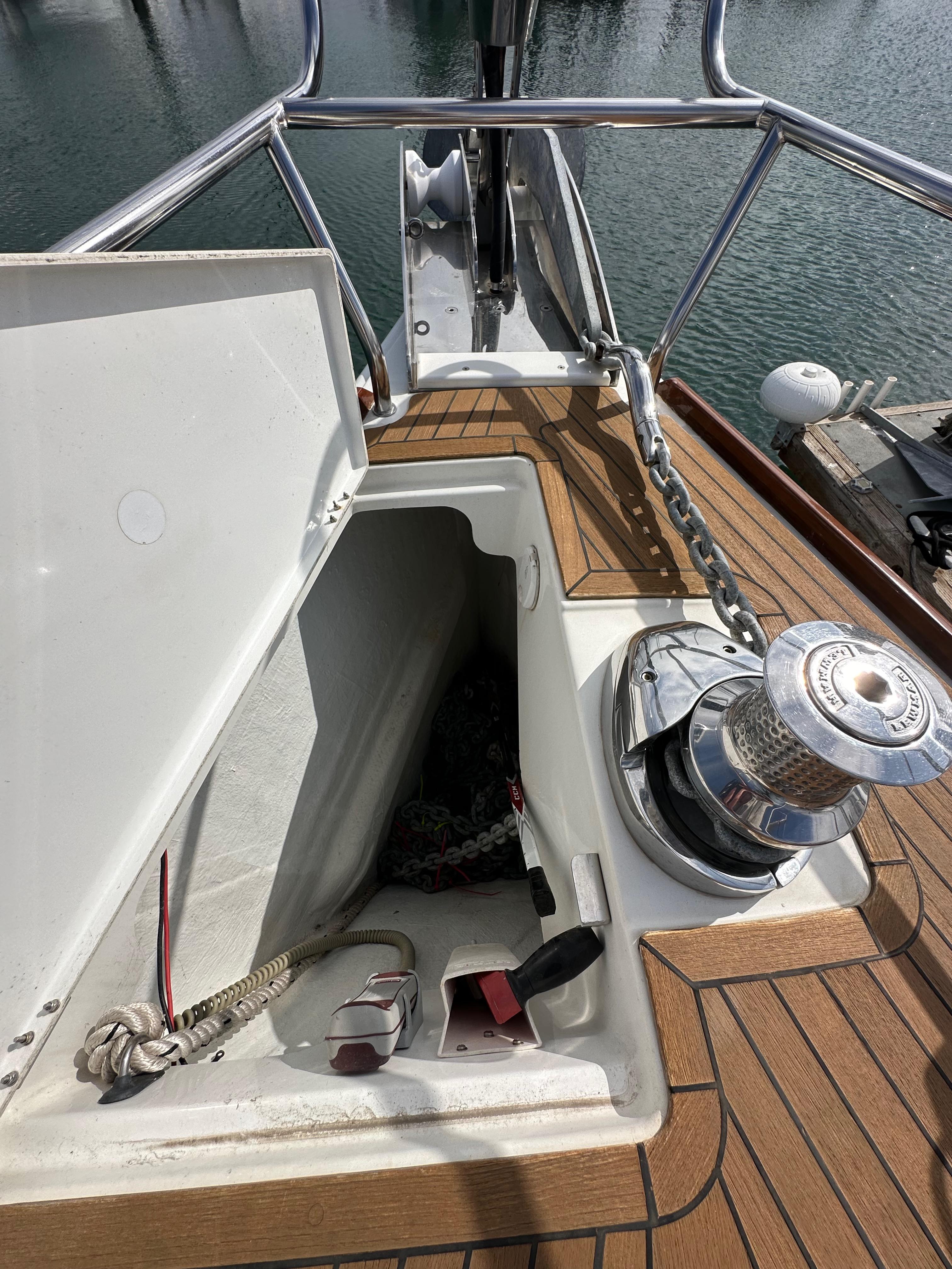 2014 Jeanneau 57 yacht deck with open storage compartment and winch.