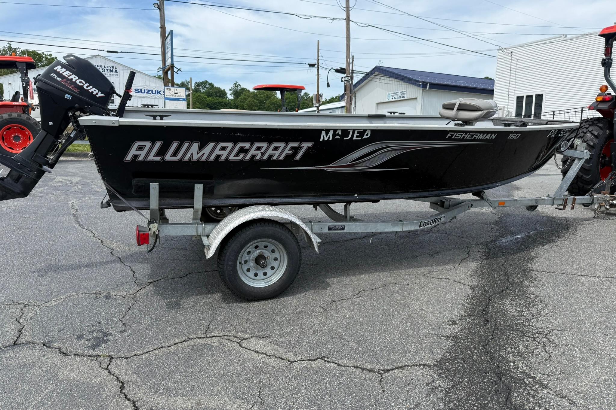 2013 Alumacraft Fisherman 160 Tiller boat on trailer, featuring Mercury outboard motor.