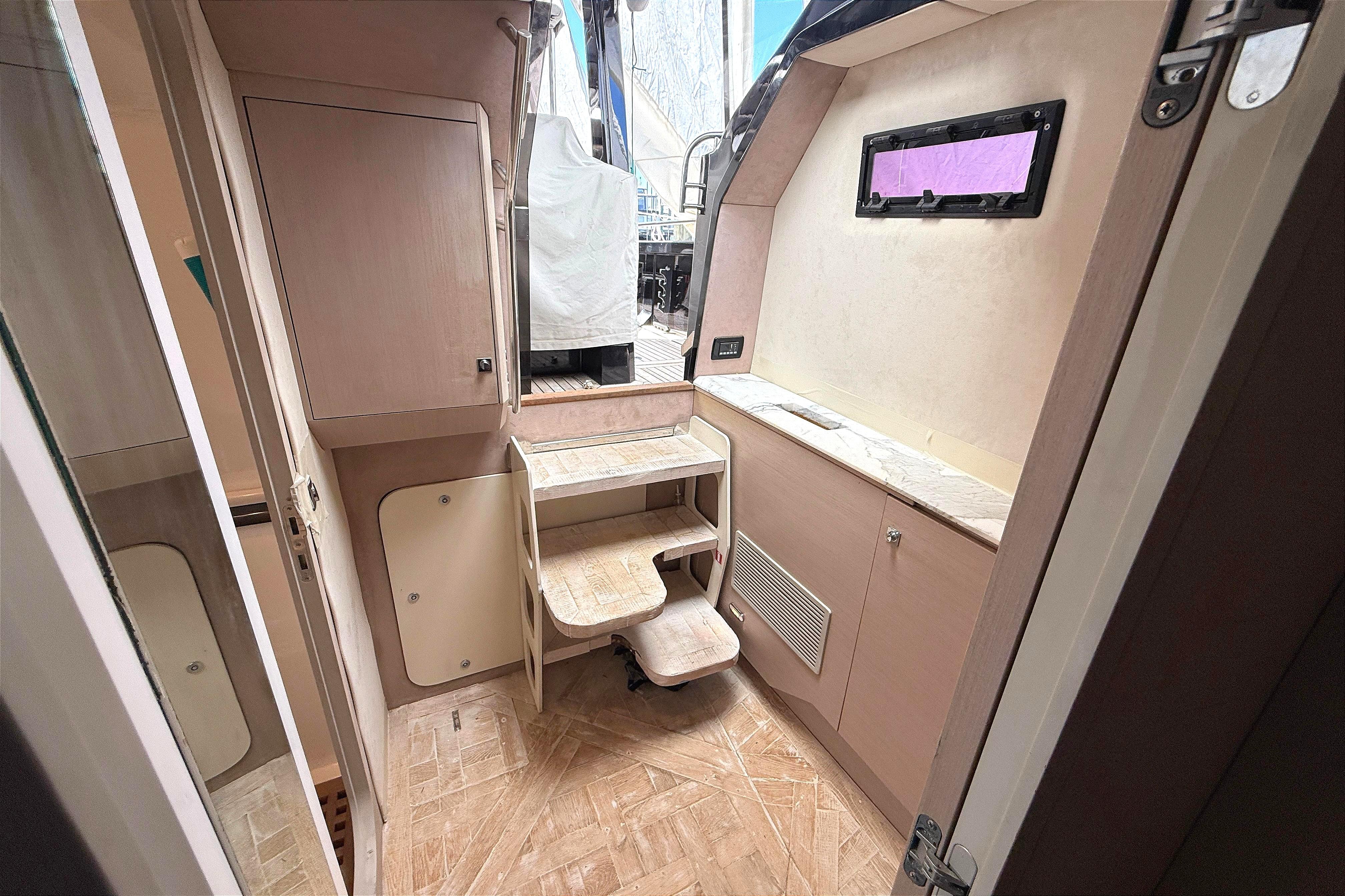 Interior of 2013 Windy SR52 yacht with wooden cabinetry and compact design.
