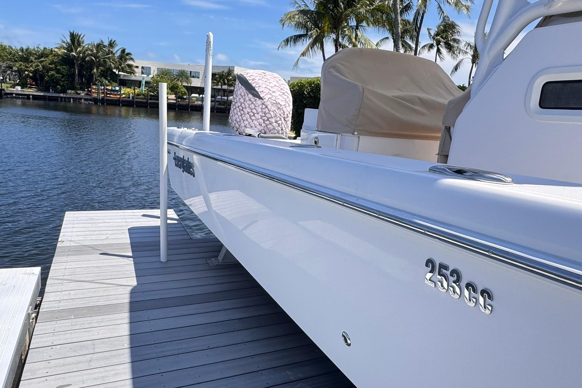 2018 Everglades 253 Center Console boat docked by a scenic waterfront.