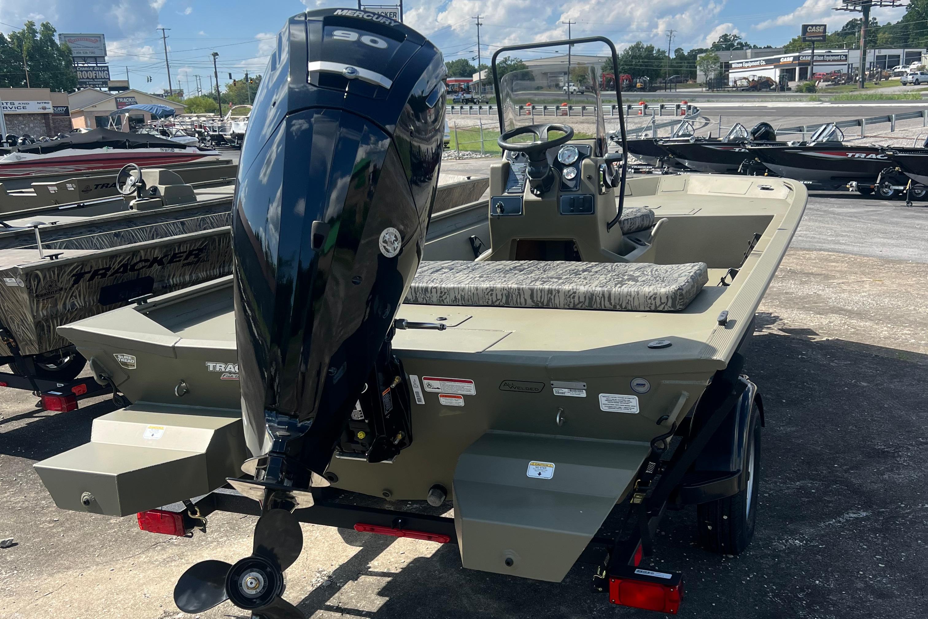 2026 Tracker Grizzly 1860 CC boat with powerful outboard motor, parked outdoors.