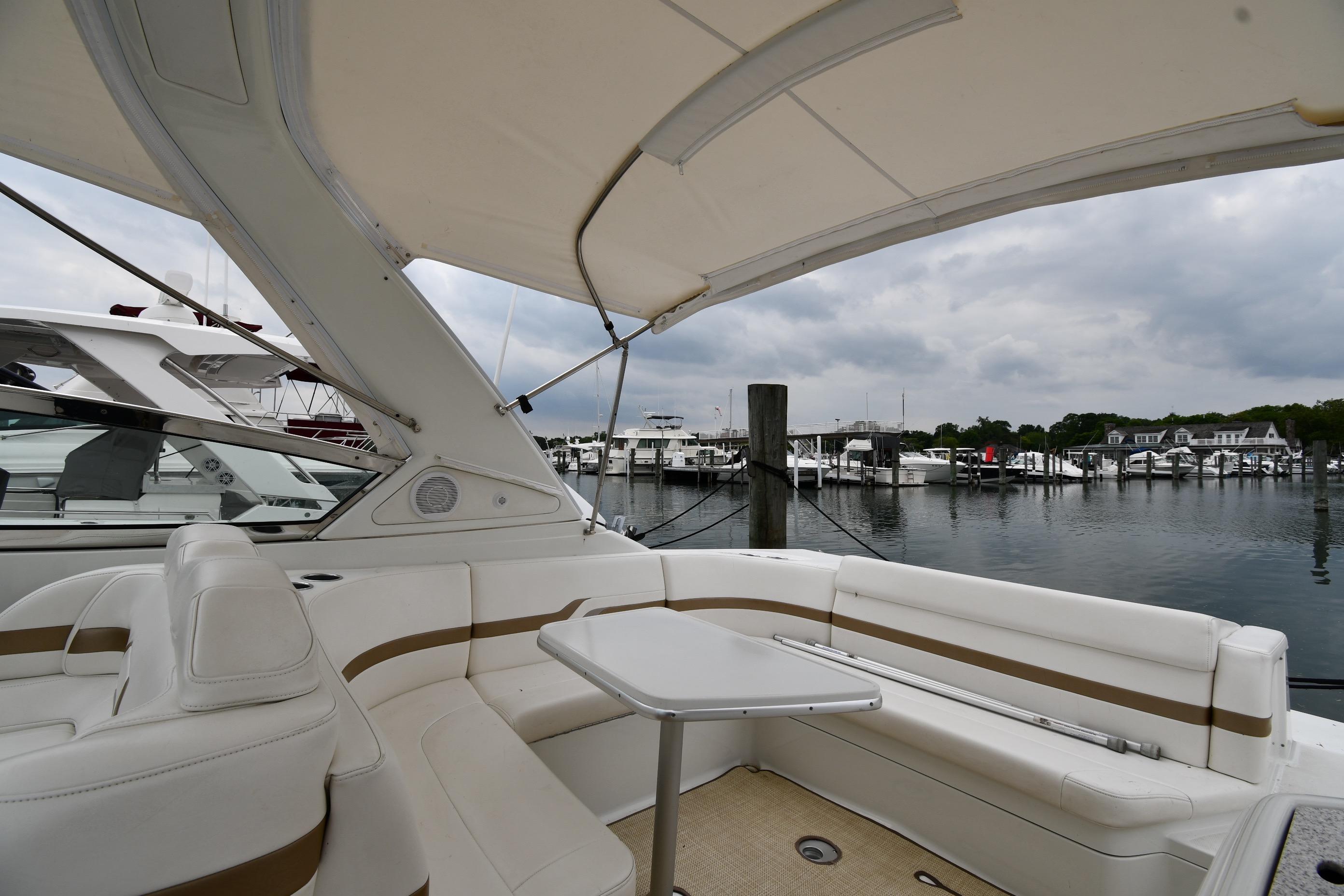 2004 Formula 330 Sun Sport boat interior with marina view, featuring white seating and table.