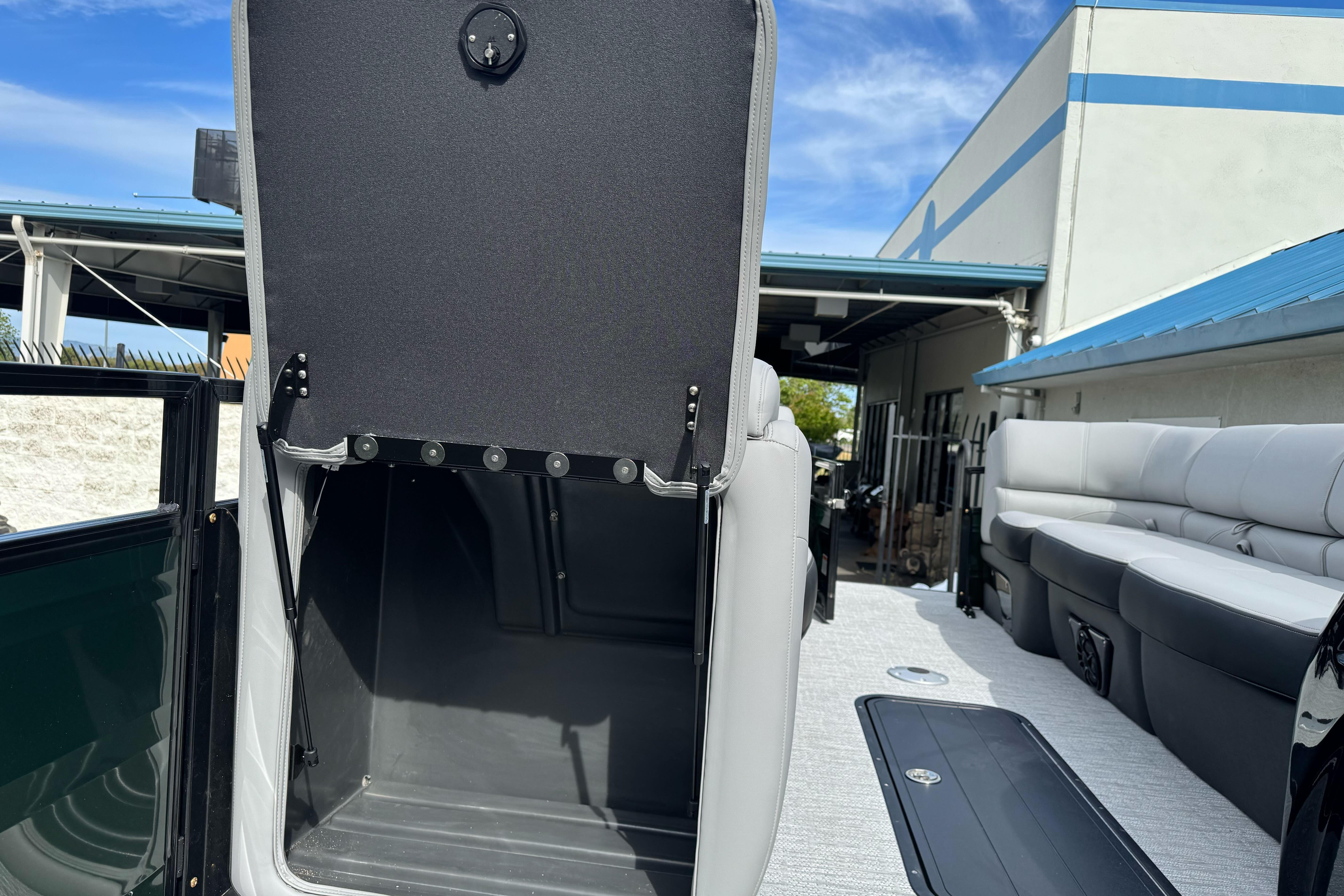 2026 Regency 250 DL boat interior with open storage compartment and seating area.