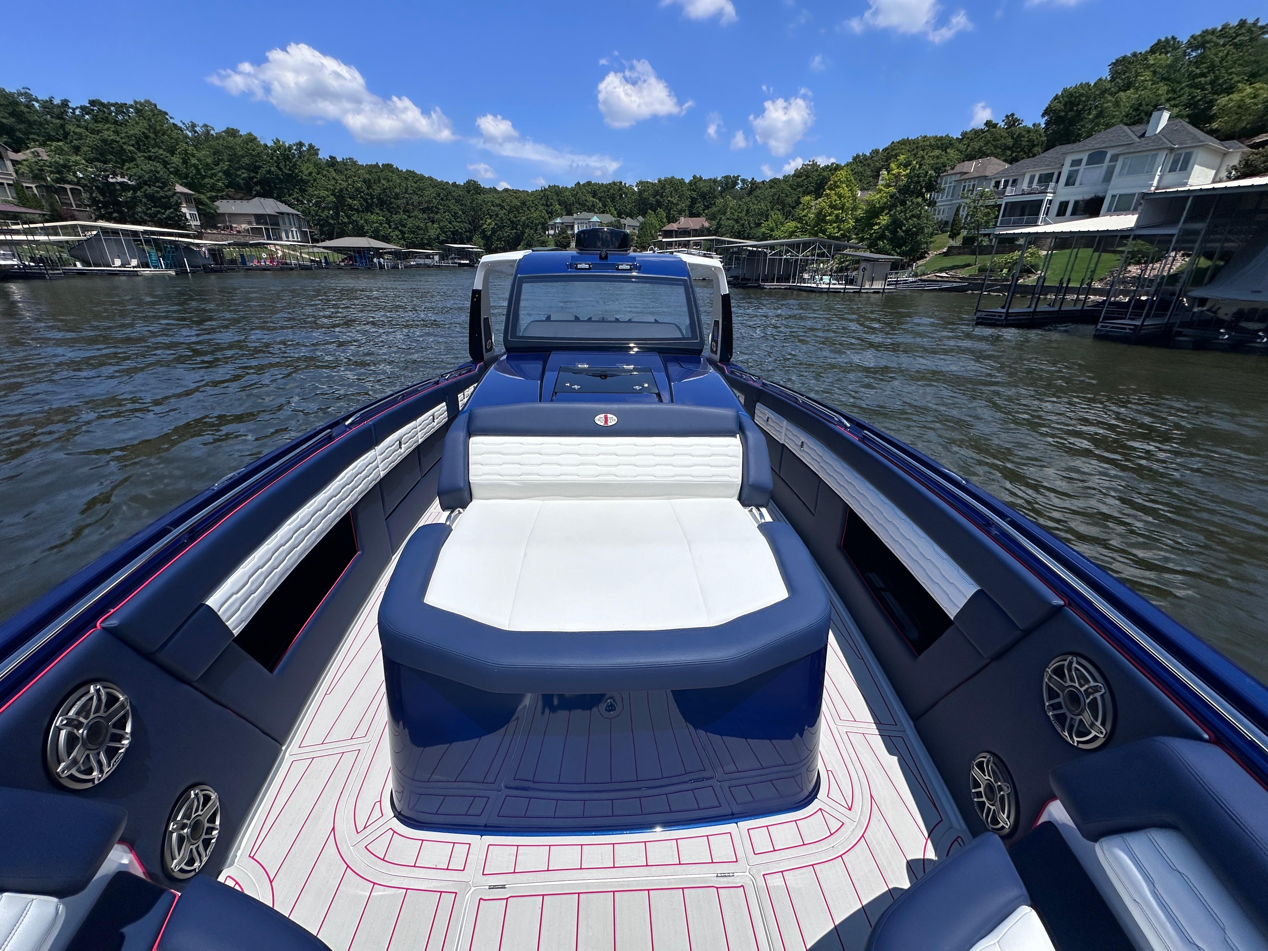 2024 Cigarette 42 Auroris boat on a lake, featuring luxurious seating and scenic surroundings.