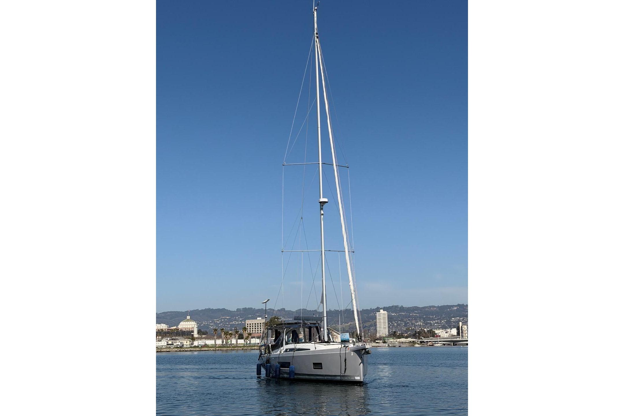 Sailing yacht Beneteau Oceanis 461, 2022 model, on calm water with cityscape background.