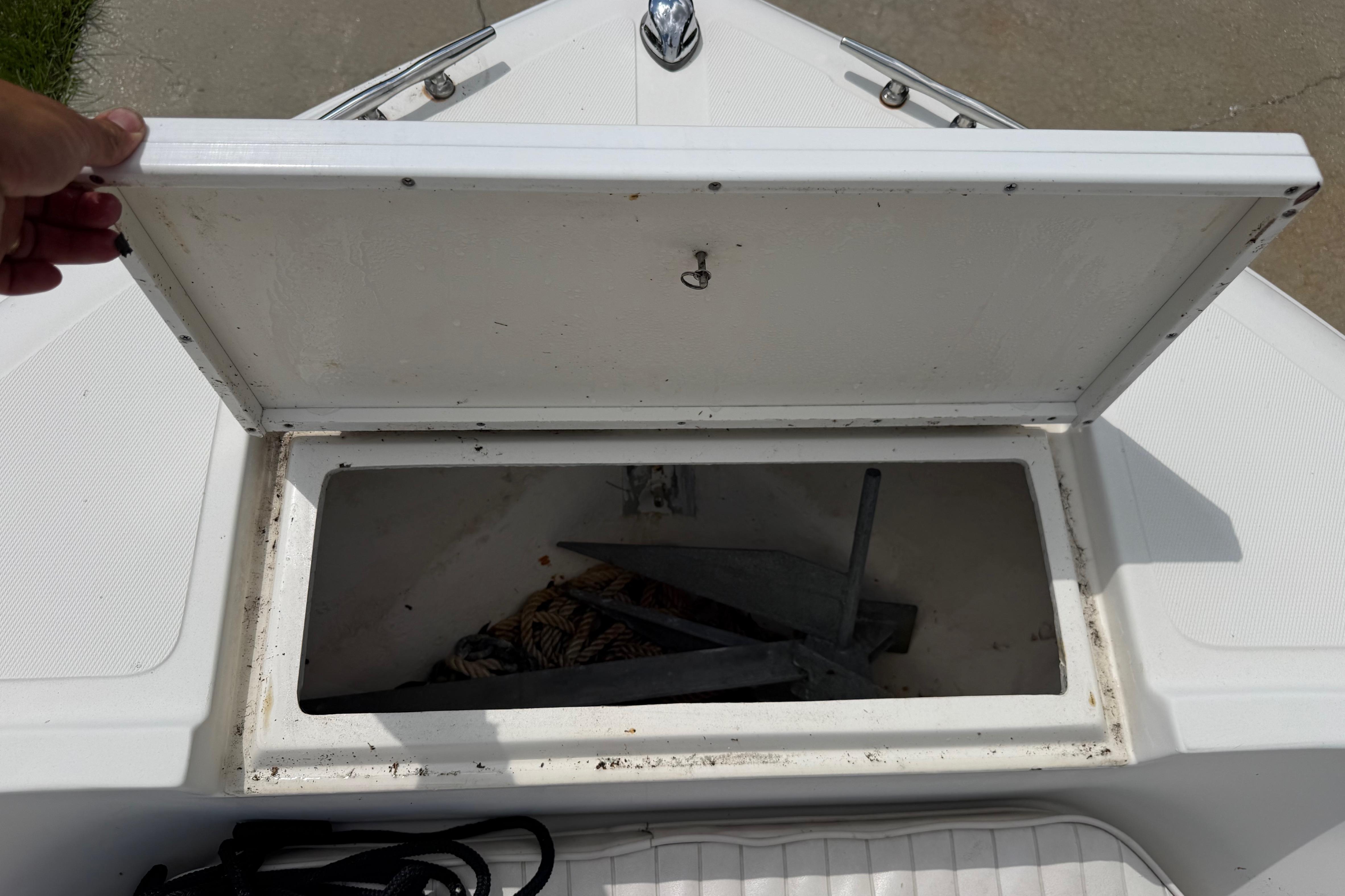 Open storage compartment on 2012 Clearwater 2000 Center Console boat, revealing anchor and rope.