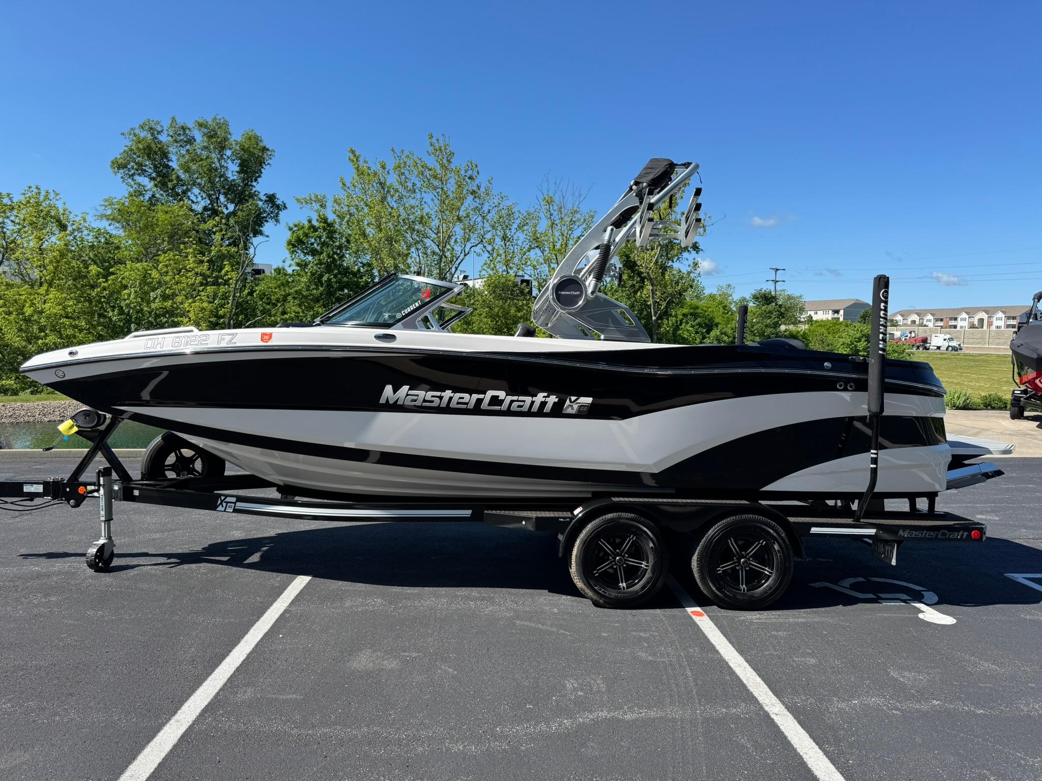 2020 MasterCraft XT22 boat on trailer in parking lot, sunny day.