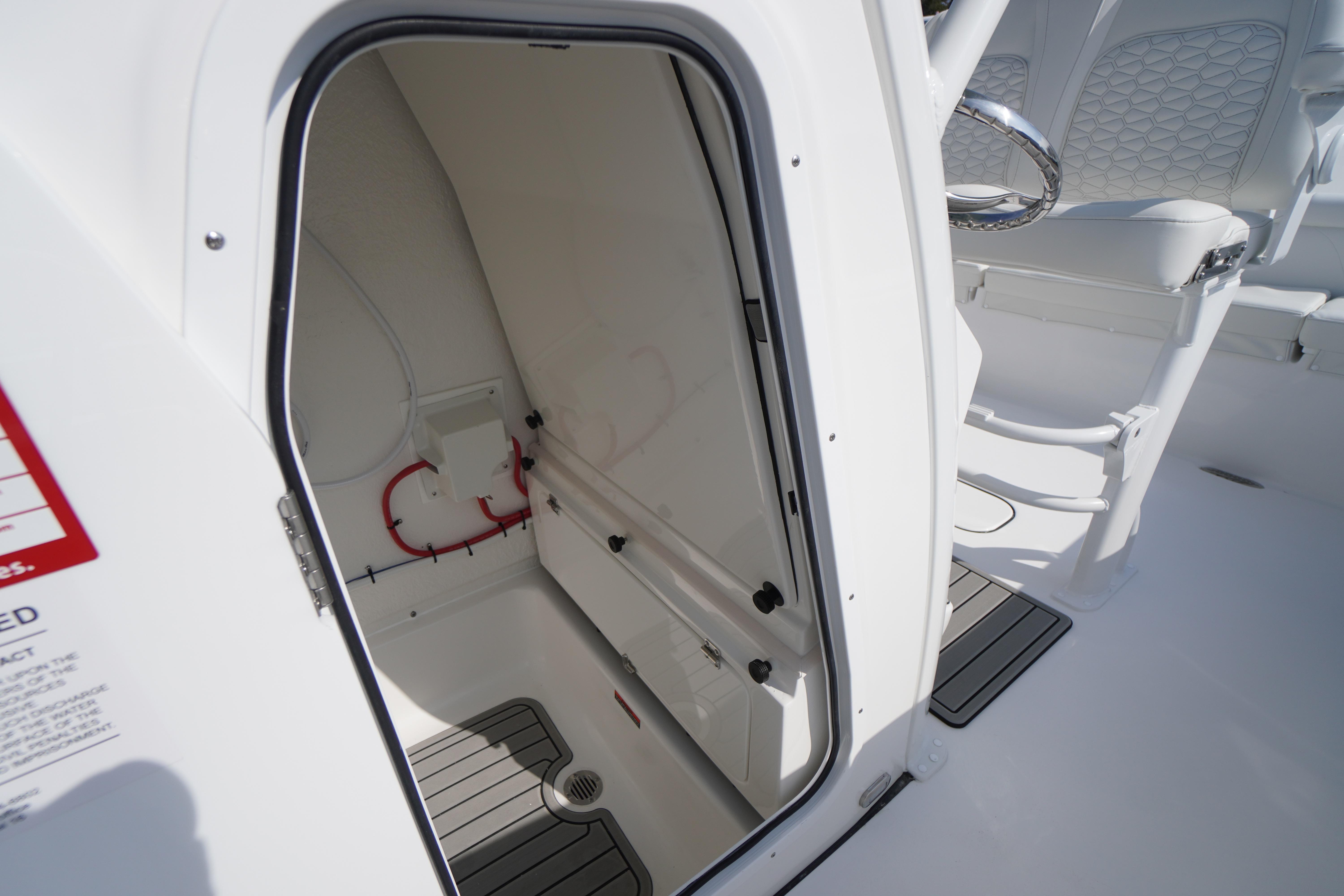 2026 Tidewater 232 LXF boat interior with open storage compartment and seating area.