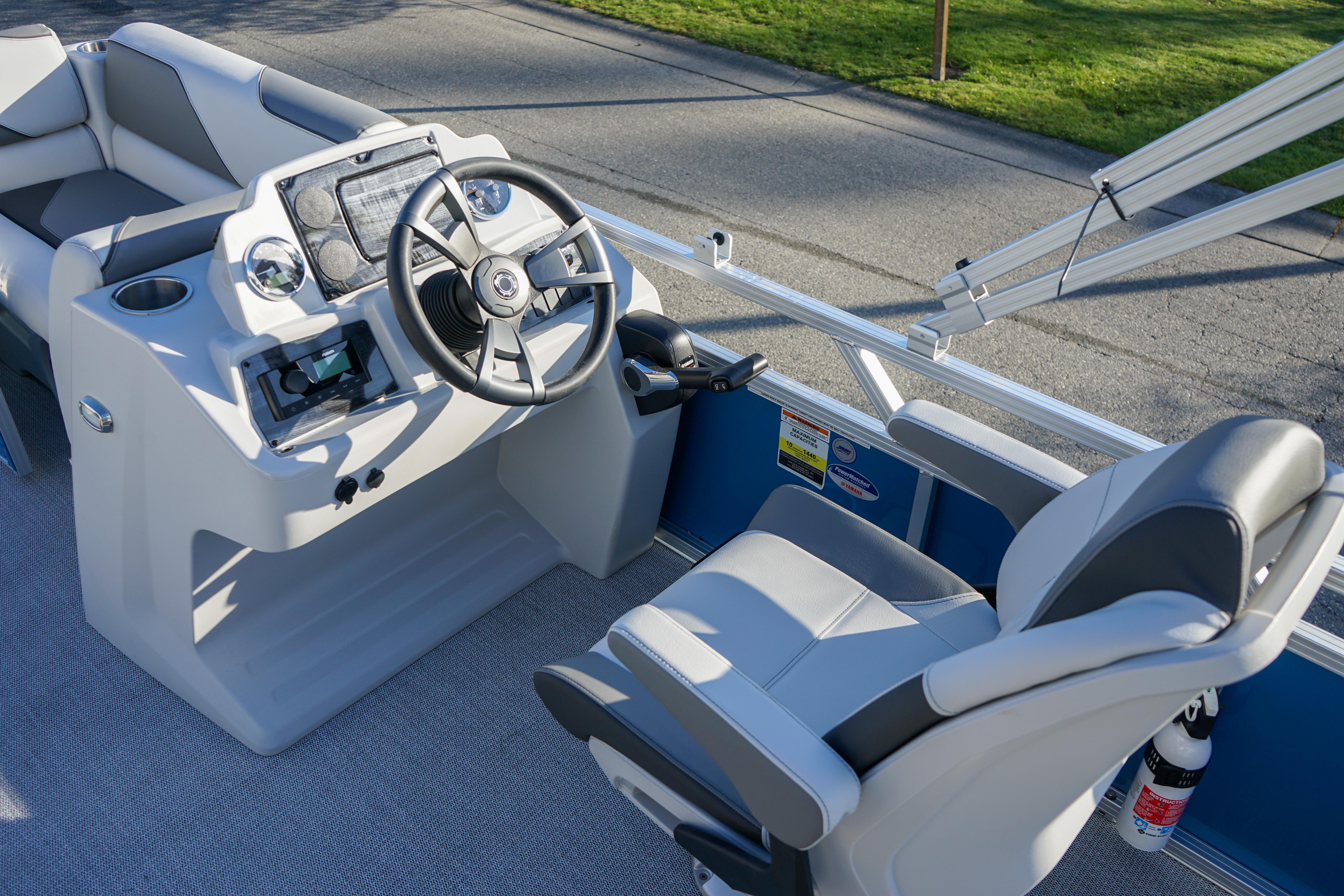 2024 Avalon 17 Venture Cruise boat interior with steering wheel and captain's chair.