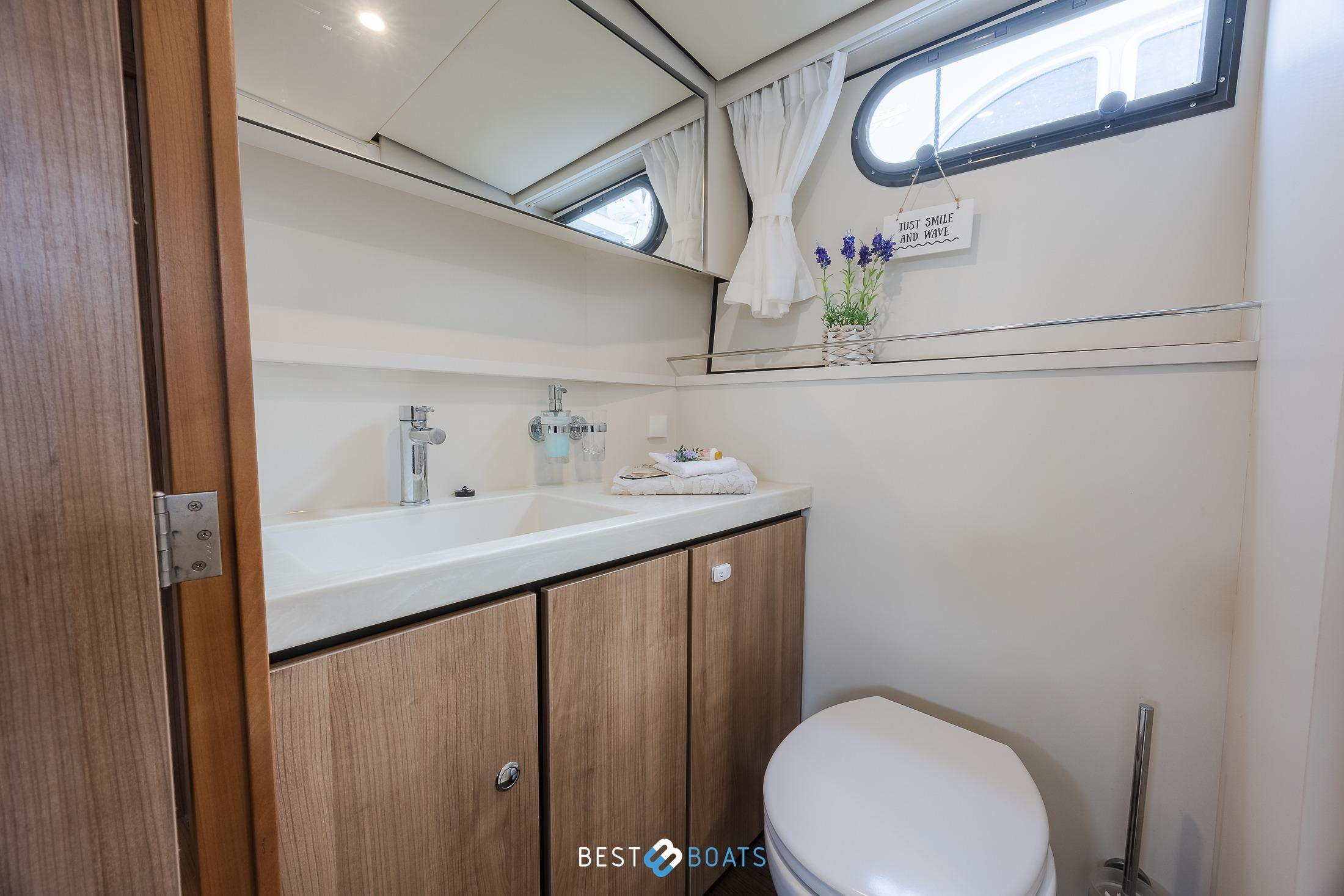 Modern bathroom in 2022 Linssen 40 SL AC yacht, featuring sleek design and wooden cabinetry.