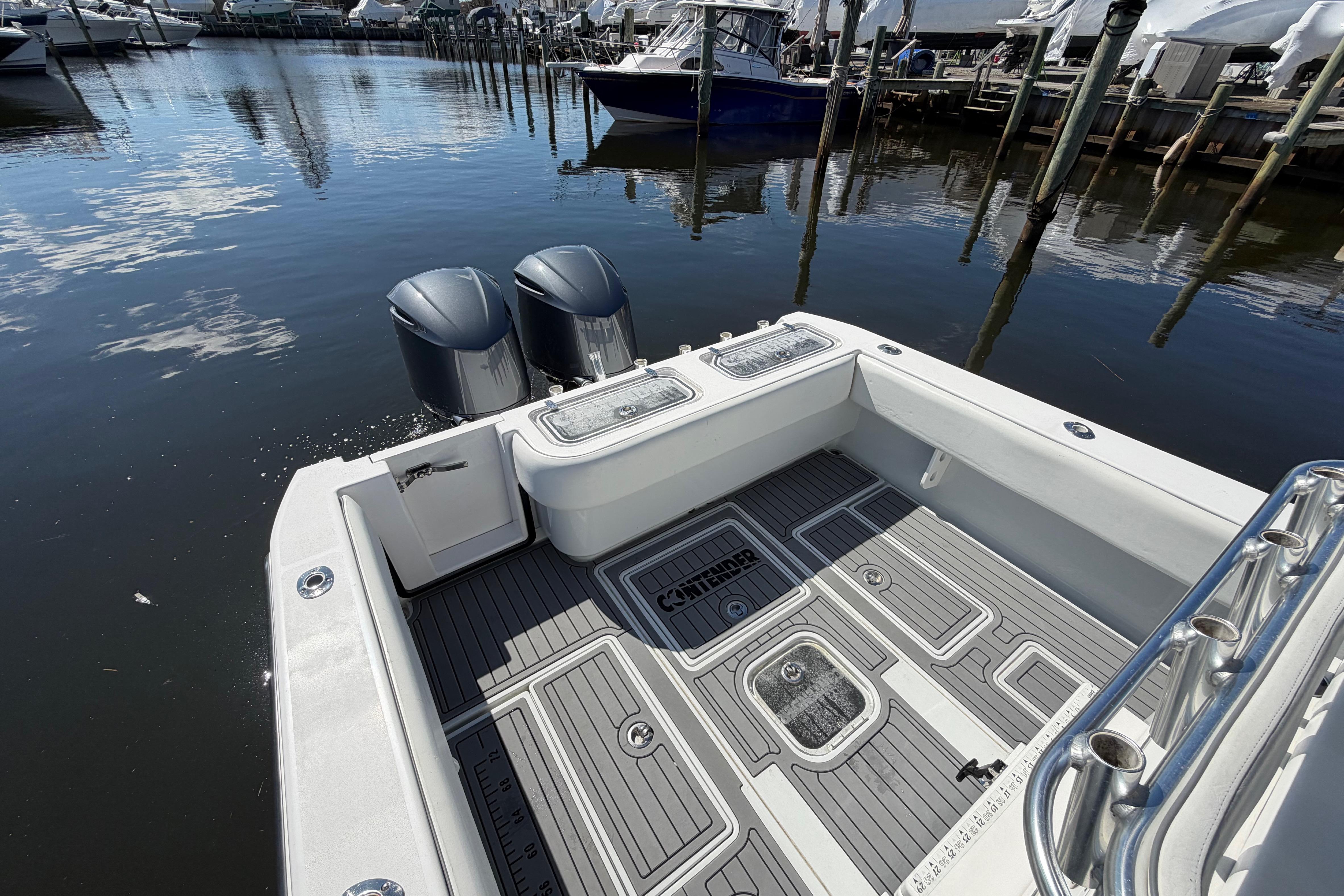 2015 Contender 32 ST boat with dual engines docked at marina.