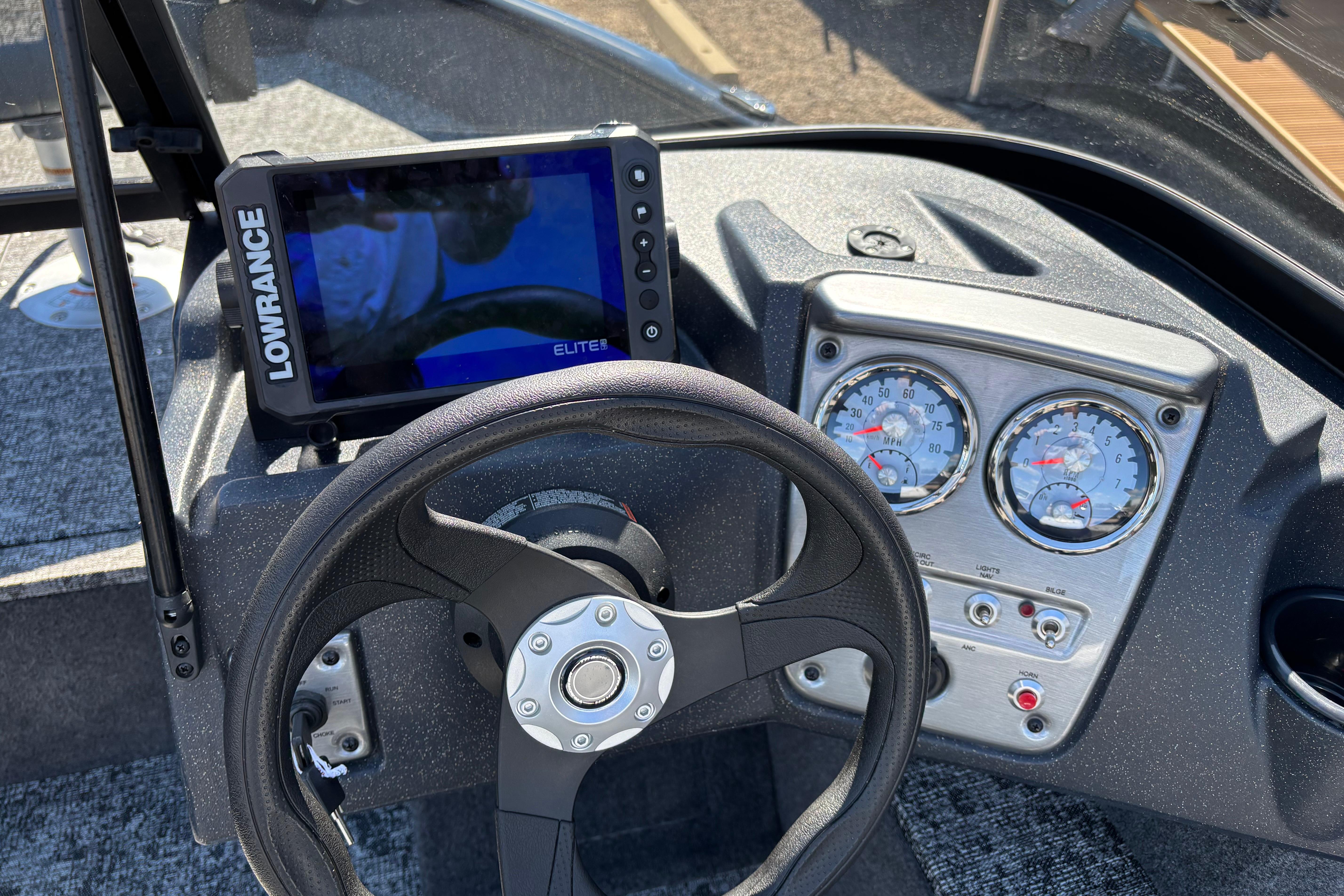 The image shows the helm of a Tracker Pro Guide V-16 WT with a Lowrance Elite fish finder.