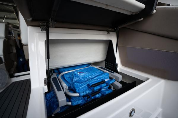 Storage compartment in a 2016 Regal 28 Express boat with blue life jackets.