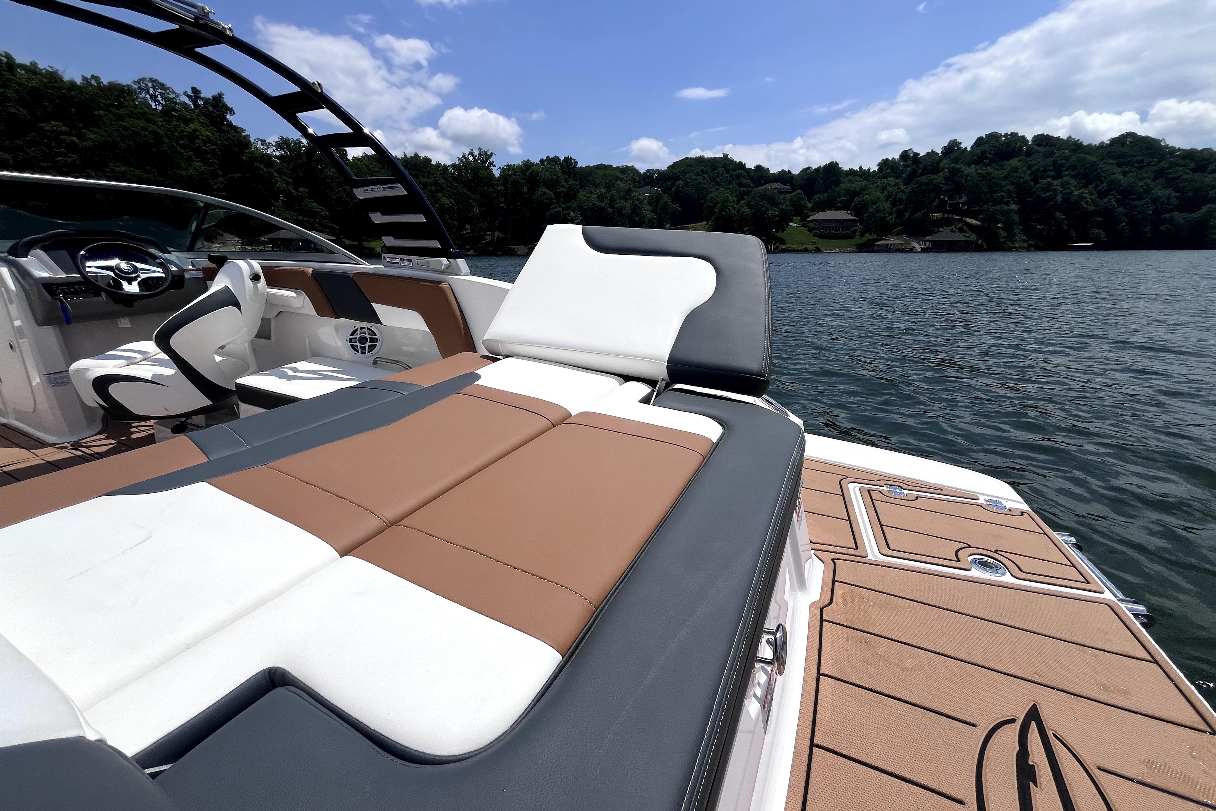2025 Chaparral 230 SSi boat interior with luxurious seating on a scenic lake.