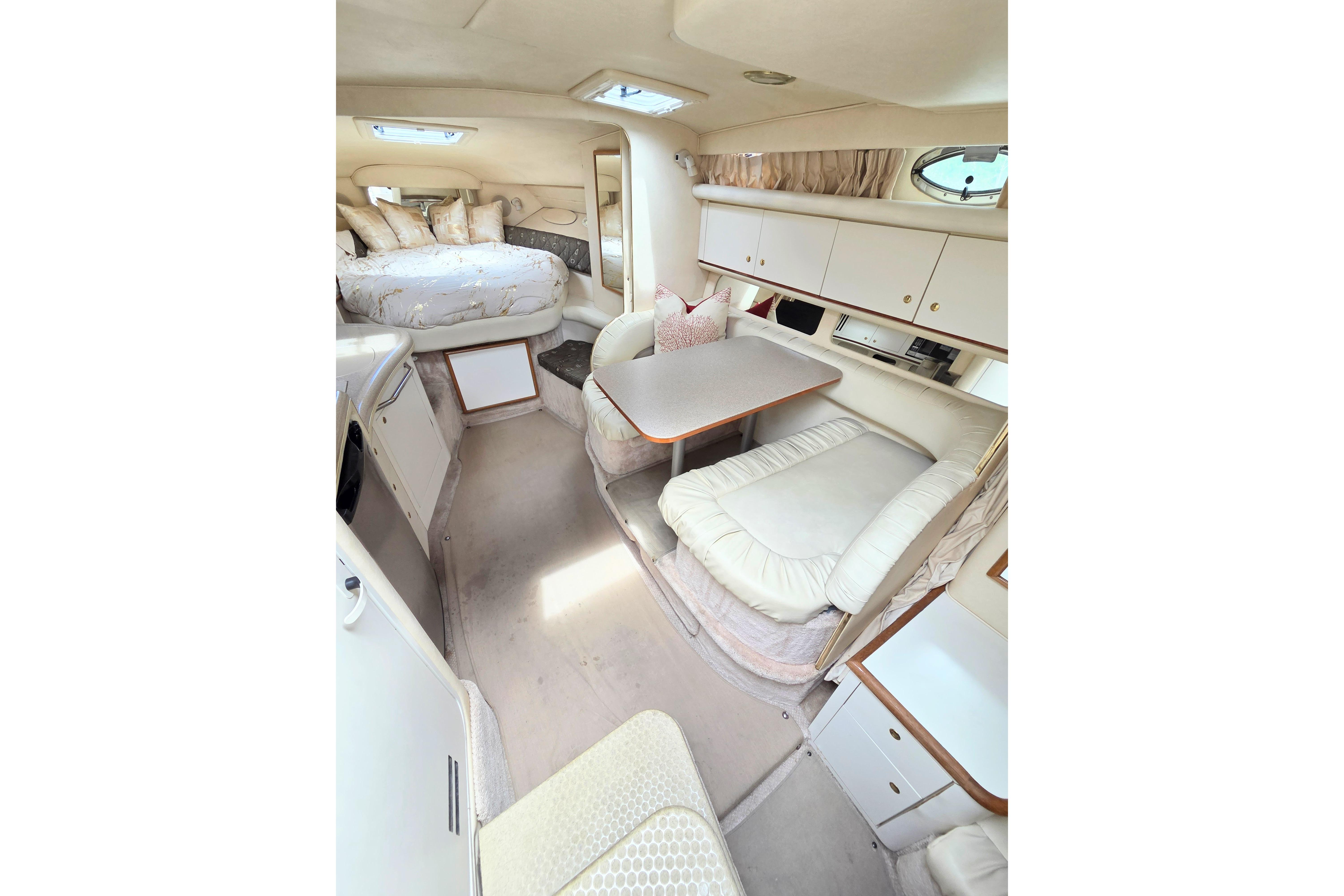 Interior of 2000 Sea Ray 340 Sundancer yacht with cozy seating and sleeping area.