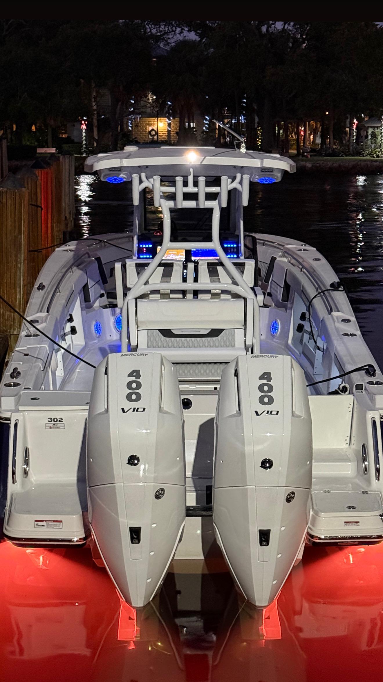2025 Blackfin 302 CC boat with dual 400 V10 engines, illuminated at night.
