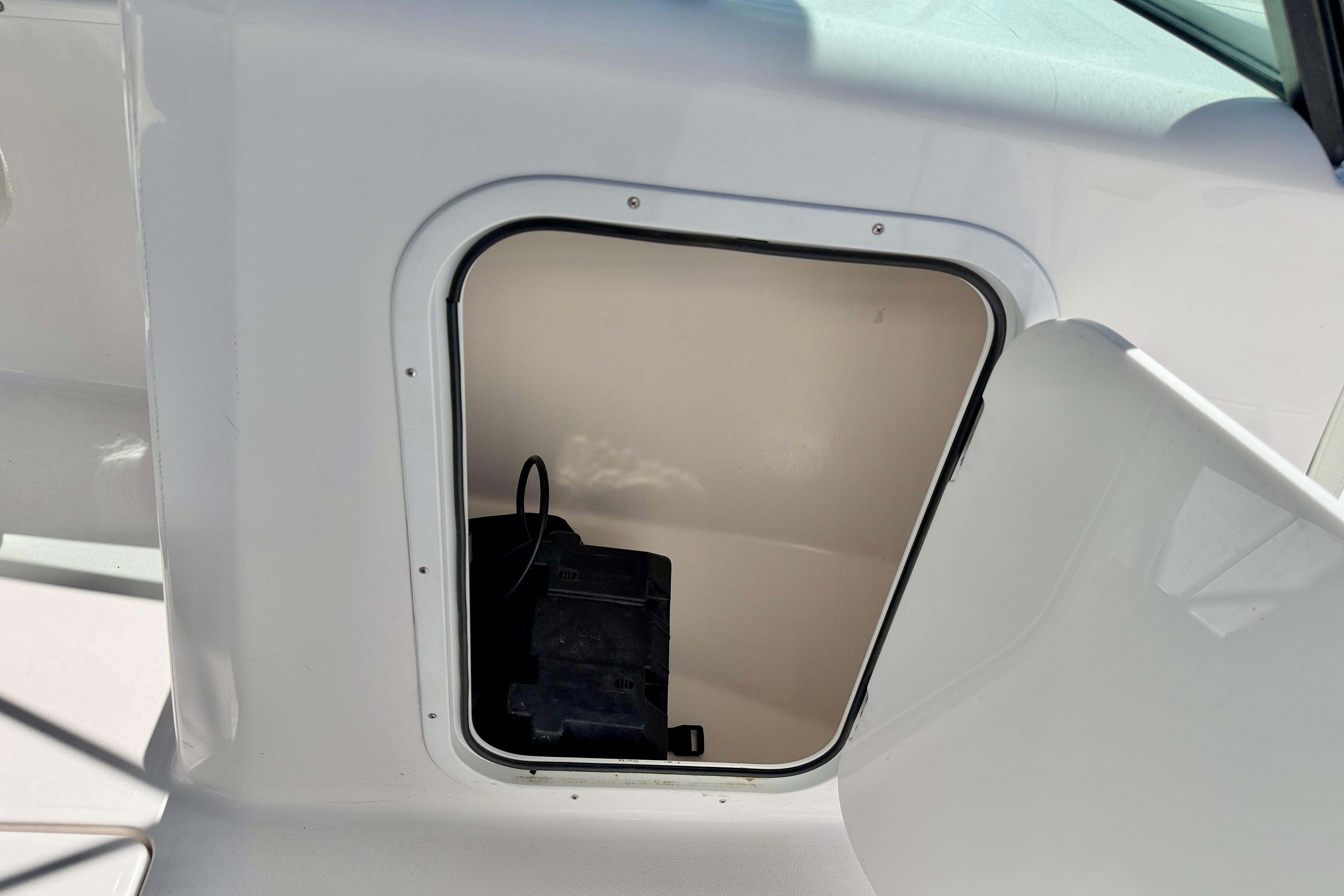 2023 Aquasport 2200 Dual Console storage compartment with open hatch.