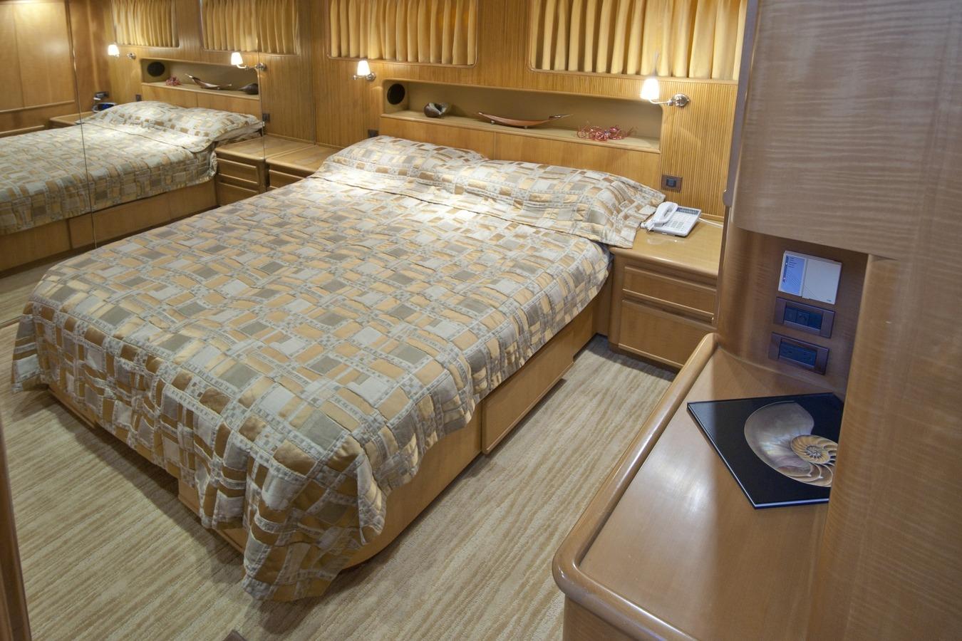Luxurious 1995 Custom Heisley bedroom with elegant wood paneling and patterned bedding.