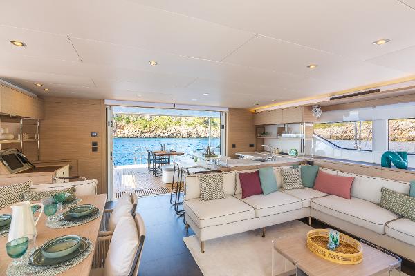Luxurious interior of 2025 Lagoon 60 yacht with ocean view and elegant furnishings.