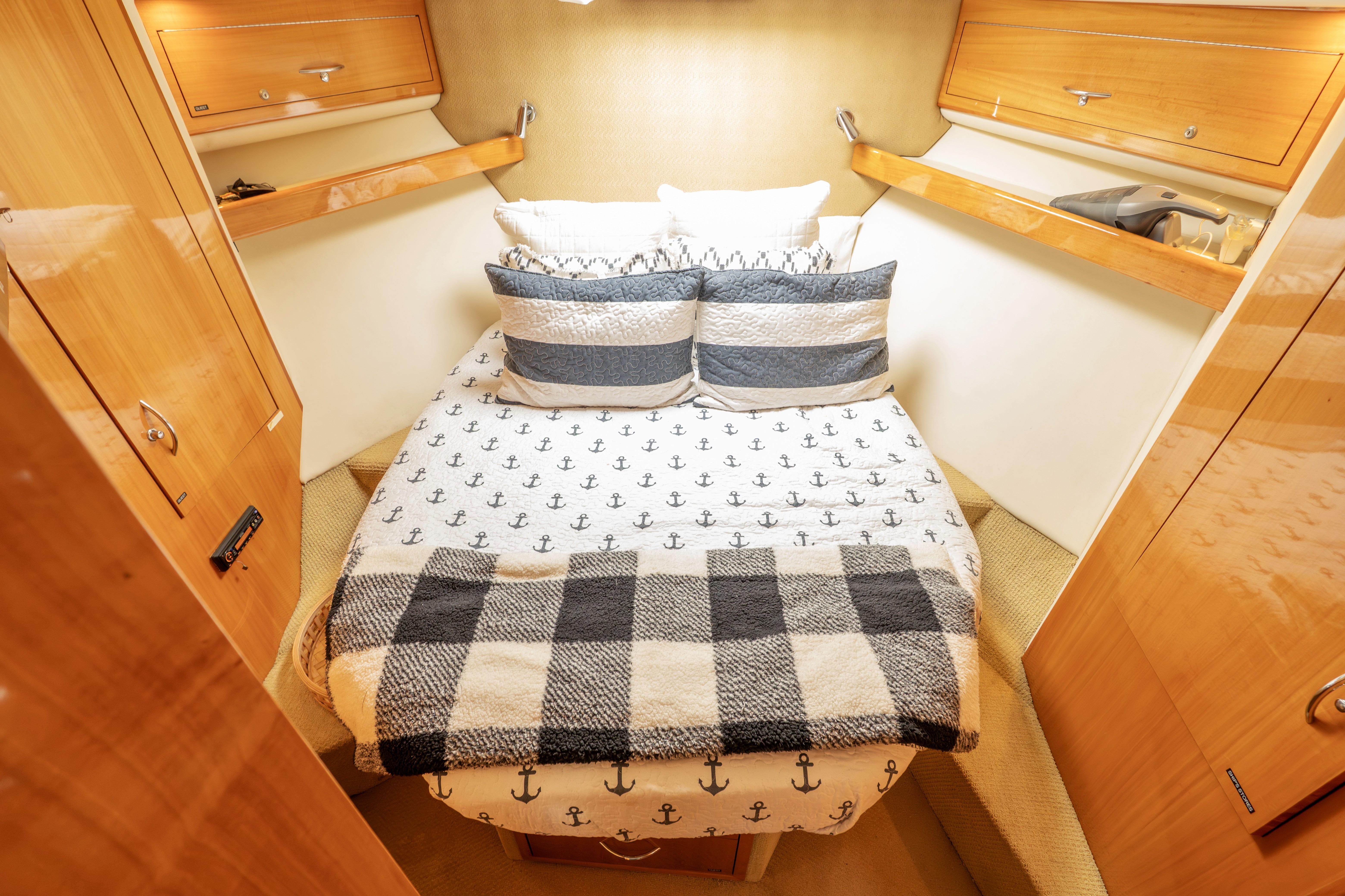 Cozy cabin interior of 2008 Maritimo 52 yacht with nautical-themed bedding.