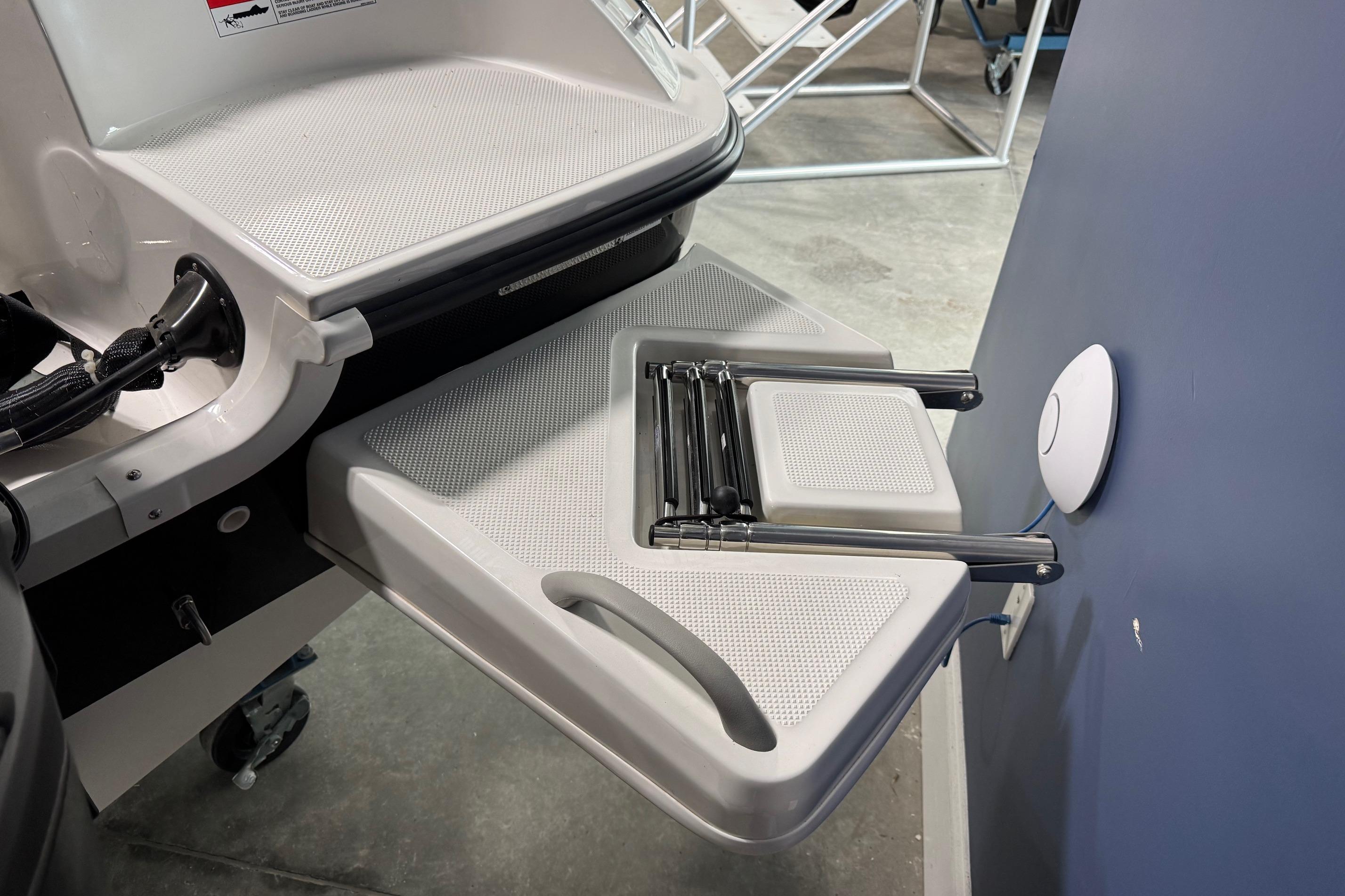 2026 Bayliner Element E18 boat with foldable swim ladder and textured platform.