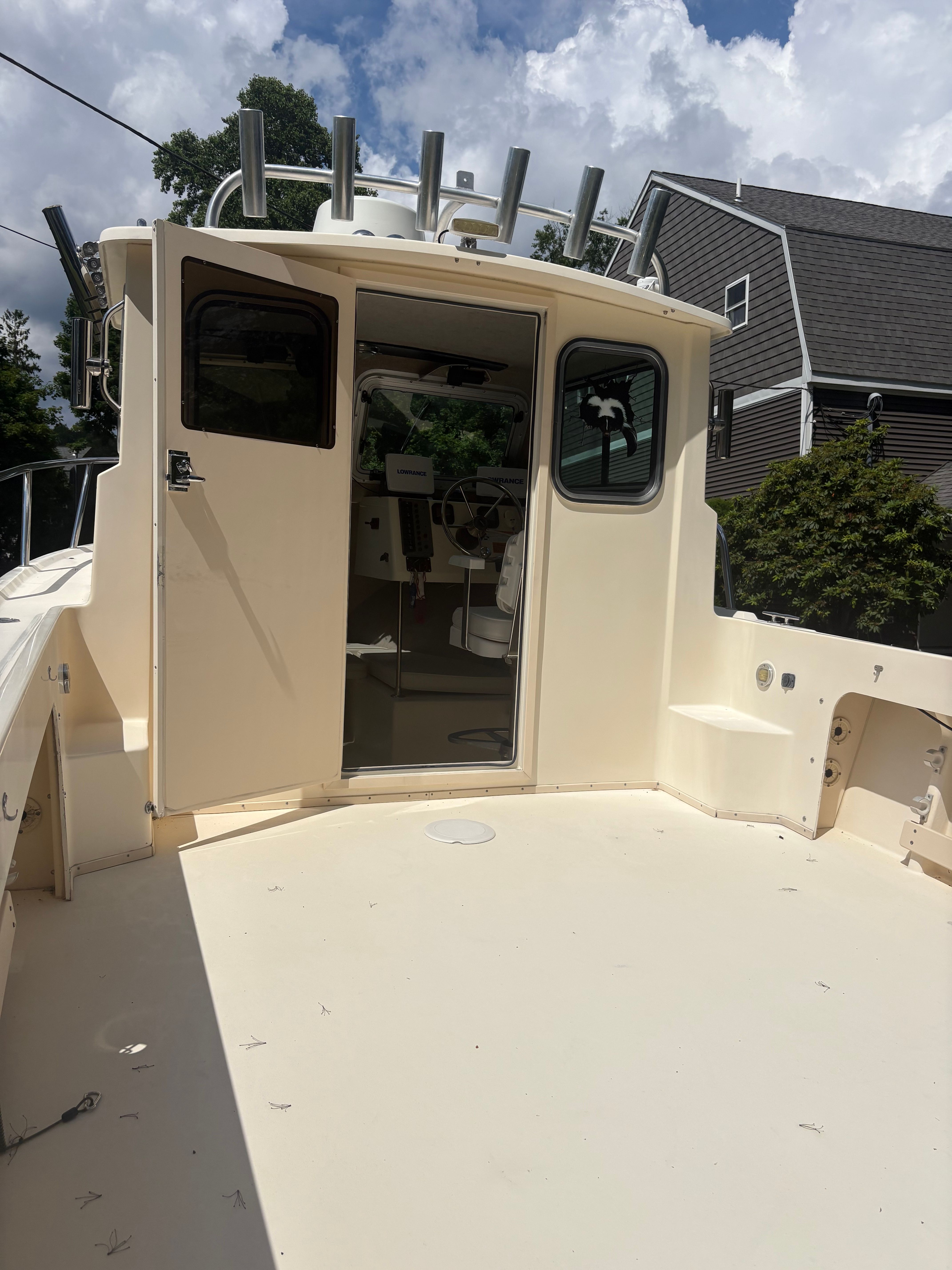 The image shows a 2009 Parker 2320 Sport Cab boat with an open cabin door.