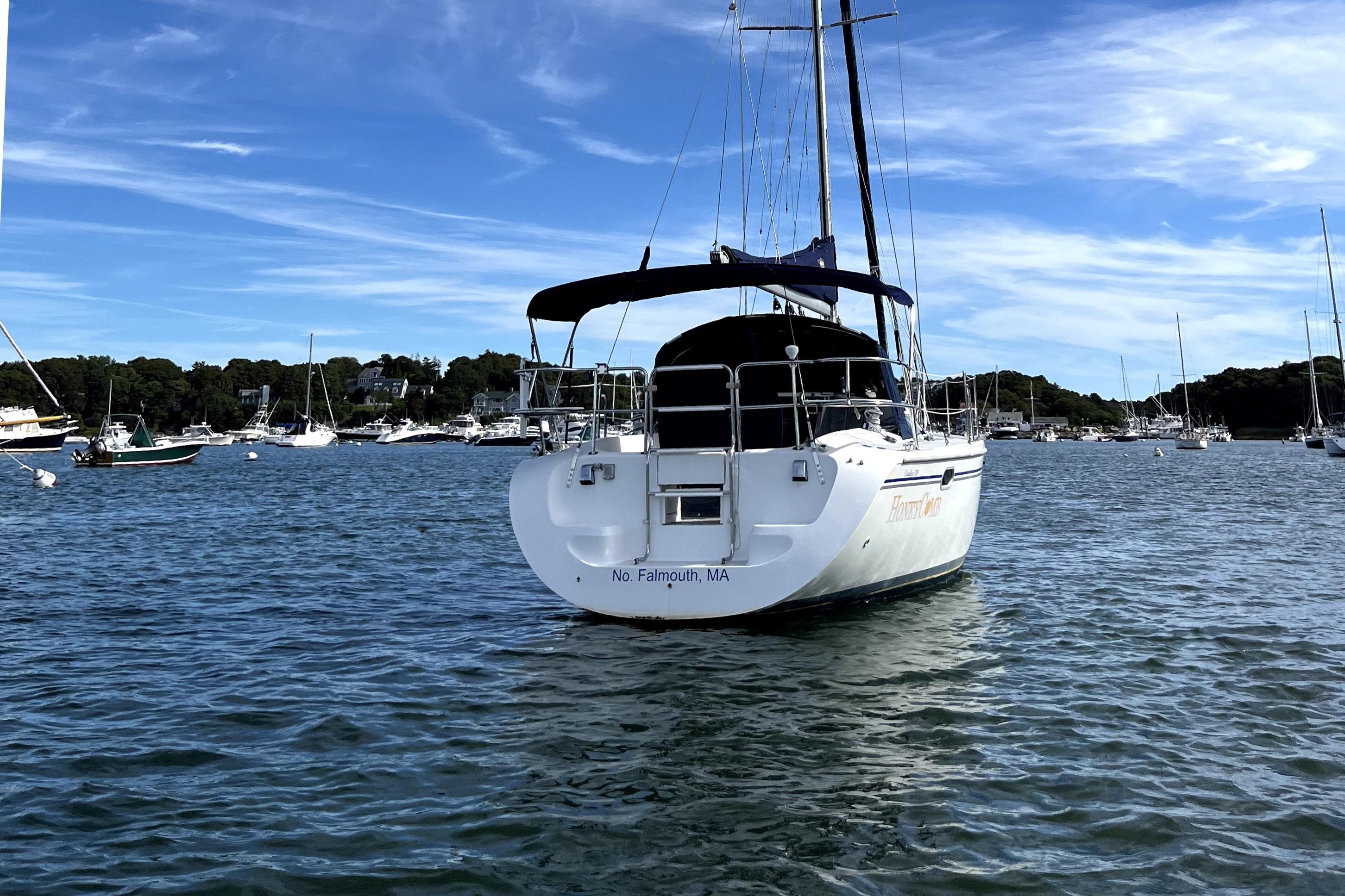 Sailboat Catalina 320, 2003 model, anchored in a scenic harbor with clear blue skies.