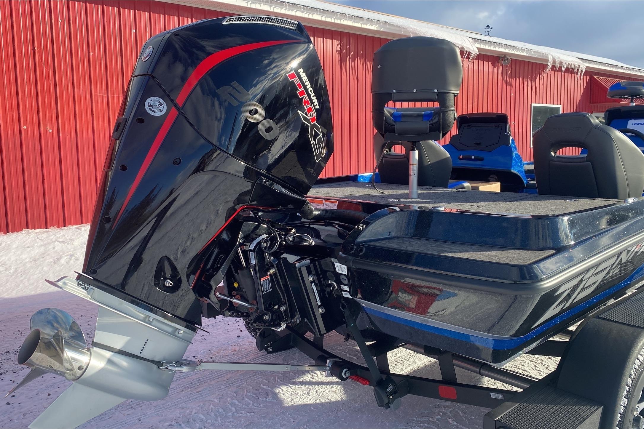 2026 Nitro Z19 XL boat with powerful Mercury engine, parked near red building.