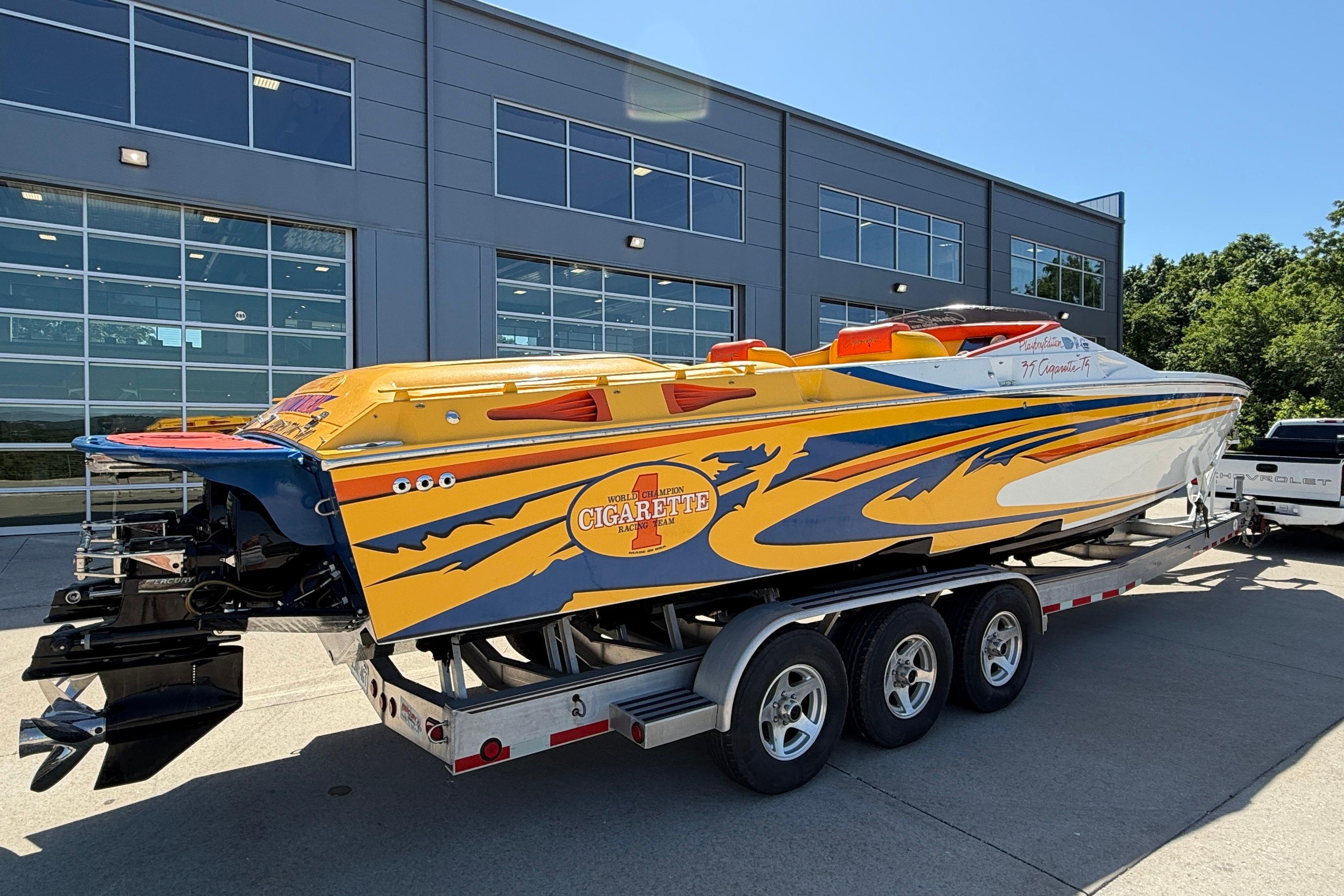 2002 Cigarette 35' Cafe Racer boat with vibrant yellow and blue design on a trailer.